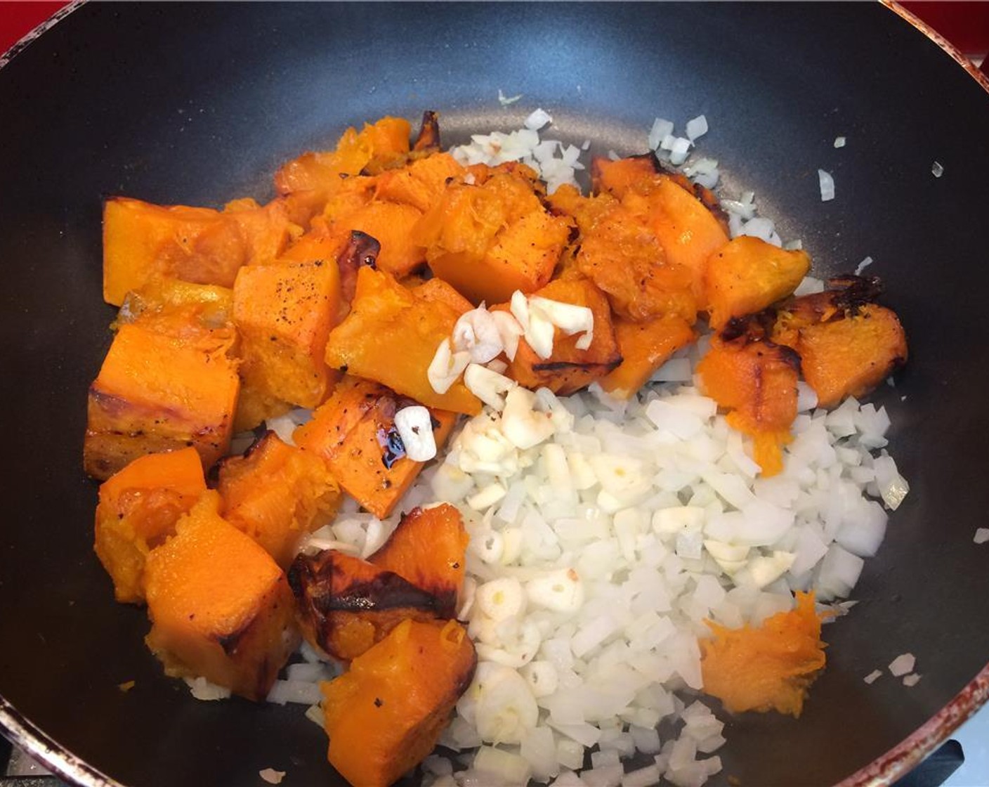 step 7 In a large pan, sweat the Onion (1/2) until transparent. Add the caramelized ginger, butternut squash, and the Garlic (4 cloves). Sauté mixture until soft.