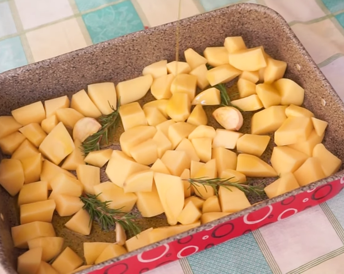 step 4 Transfer the potatoes to an oven-safe baking tray and spread them out, before adding a few short sprigs of Fresh Rosemary (to taste), Garlic (to taste) cloves with the skin still on (make a small slit with a knife directly on each clove), and Extra-Virgin Olive Oil (as needed).