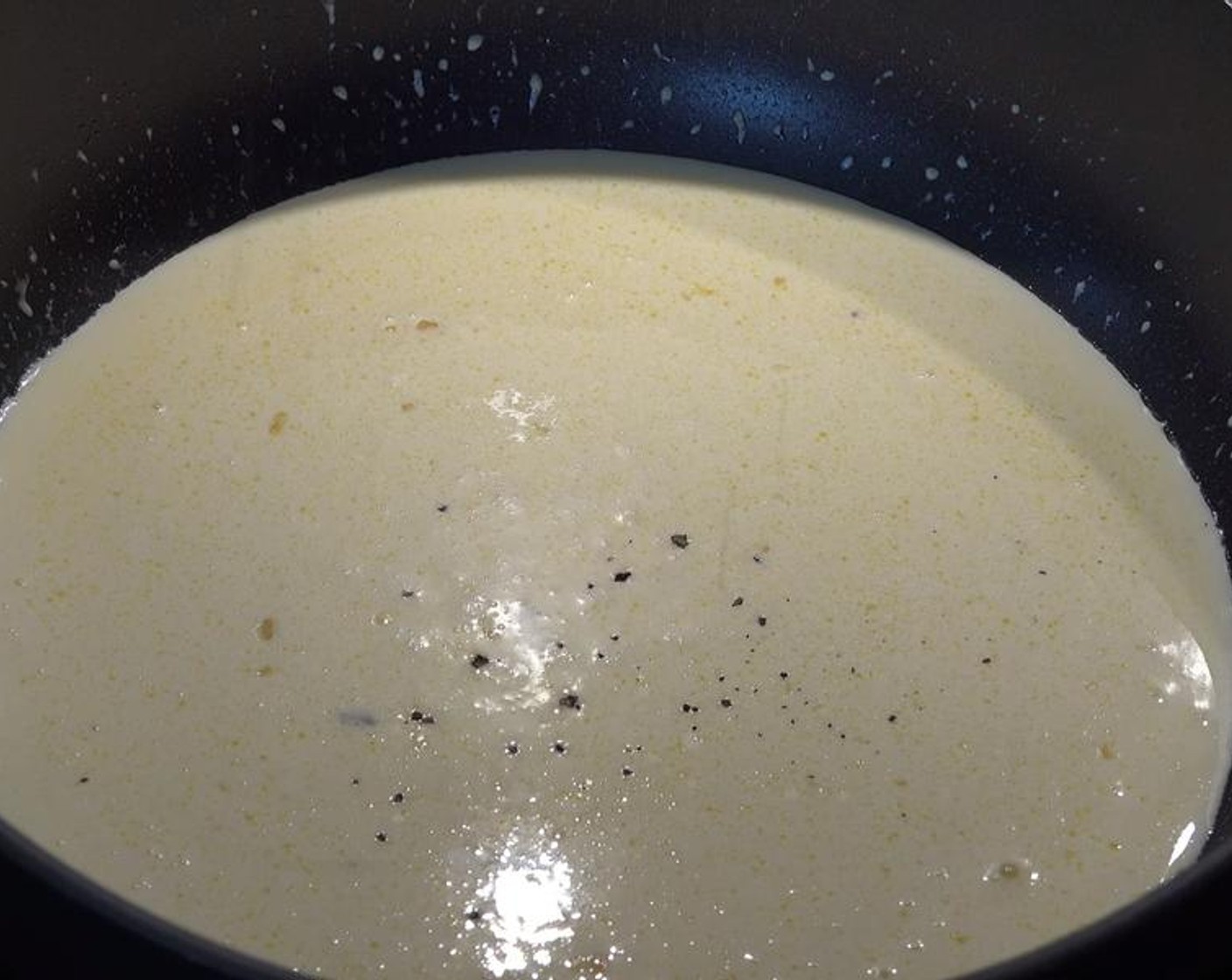 step 4 Pour Whipping Cream (1 2/3 cups) into the garlic mix and stir together. Season it with Salt (to taste) and Ground Black Pepper (to taste). Reduce the heat to low, and let the mix simmer for four minutes, or until the sauce starts to thicken.