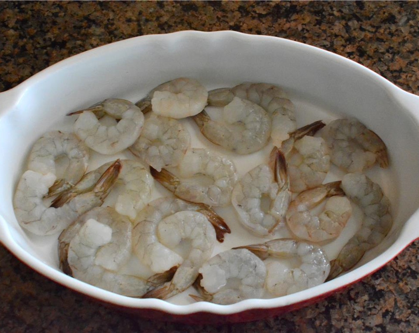 step 5 While your sauce is cooling, peel and devein the Shrimp (1 lb), if needed, and arrange them in a single layer of an oven-proof casserole dish.