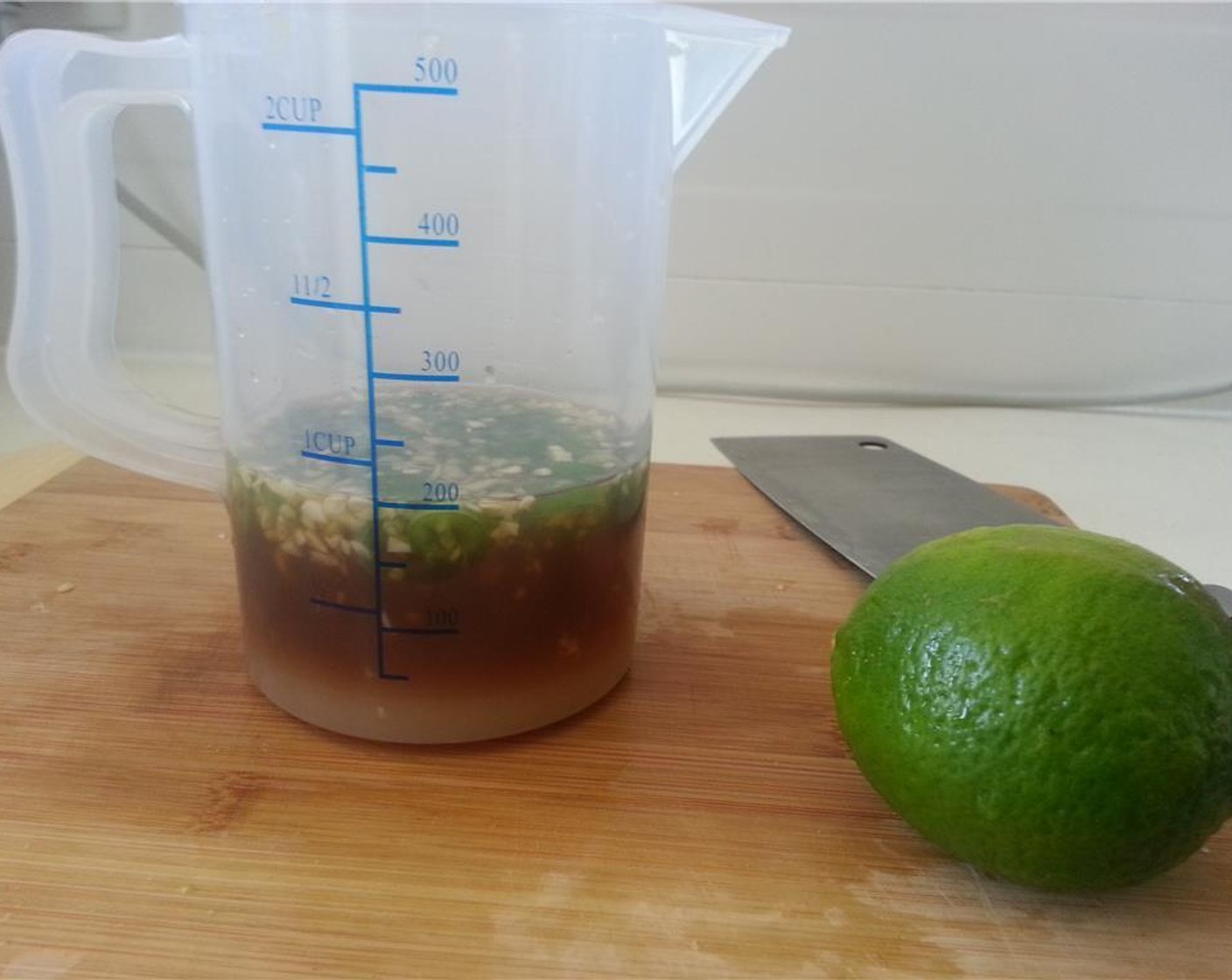 step 3 In a measuring cup, add in the Fish Sauce (1/2 cup), Water (4 Tbsp), and Rice Vinegar (2 Tbsp). Add in the garlic and pepper.