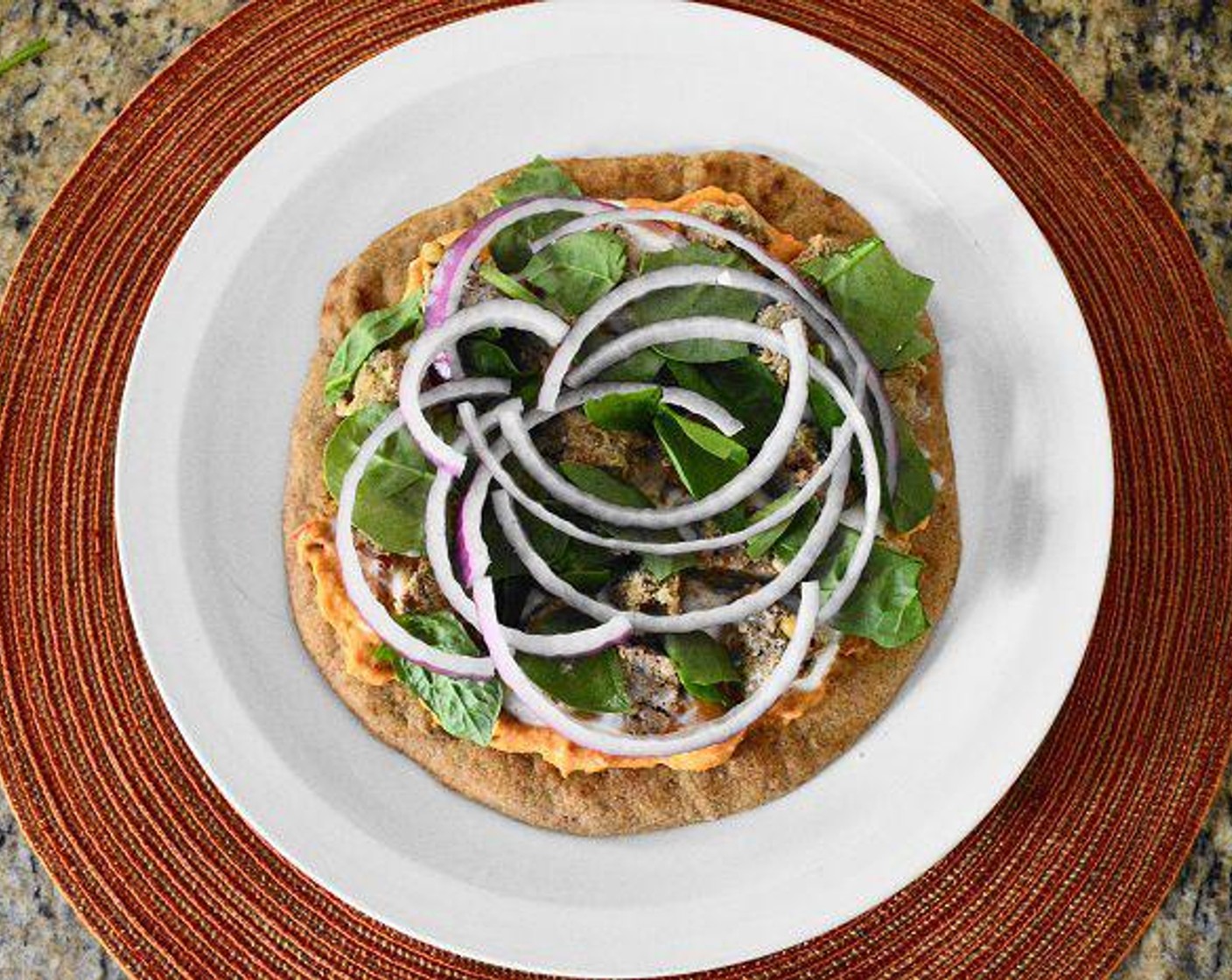 step 8 Sprinkle a generous amount of Fresh Baby Spinach (1 cup) and Red Onion (1/2) on top of the meatballs and serve the pit-zas immediately! Enjoy!