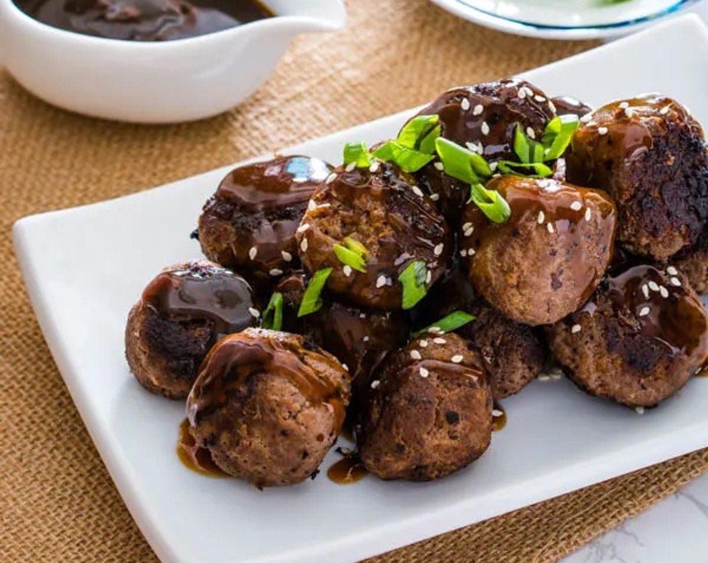 step 9 Drizzle the sauce over meatballs if desired, or serve it on the side as a dipping sauce. Garnish the meatballs with White Sesame Seeds (as needed) and Scallions (as needed). Enjoy!