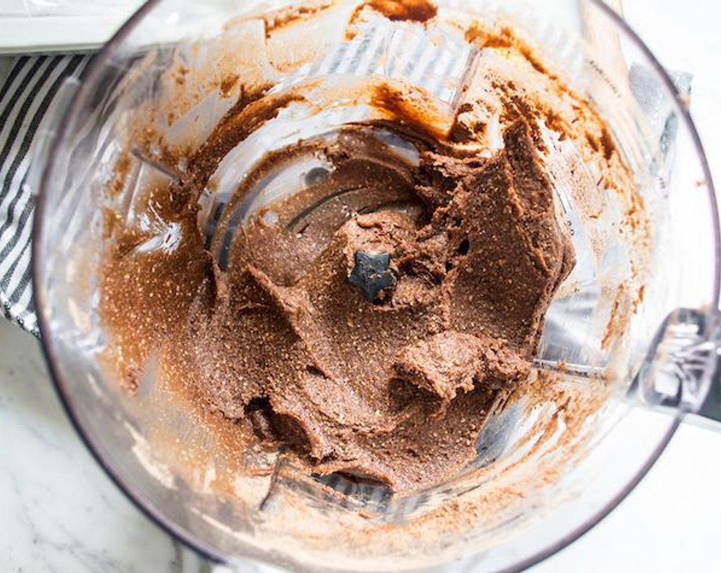 step 1 Add Raw Cashews (1/2 cup), Medjool Dates (14), Dry Roasted, Unsalted Peanuts (1/4 cup), Unsweetened Cocoa Powder (1/4 cup), and Peanut Butter (2 Tbsp) to bowl of food processor, blend for 1 minute.