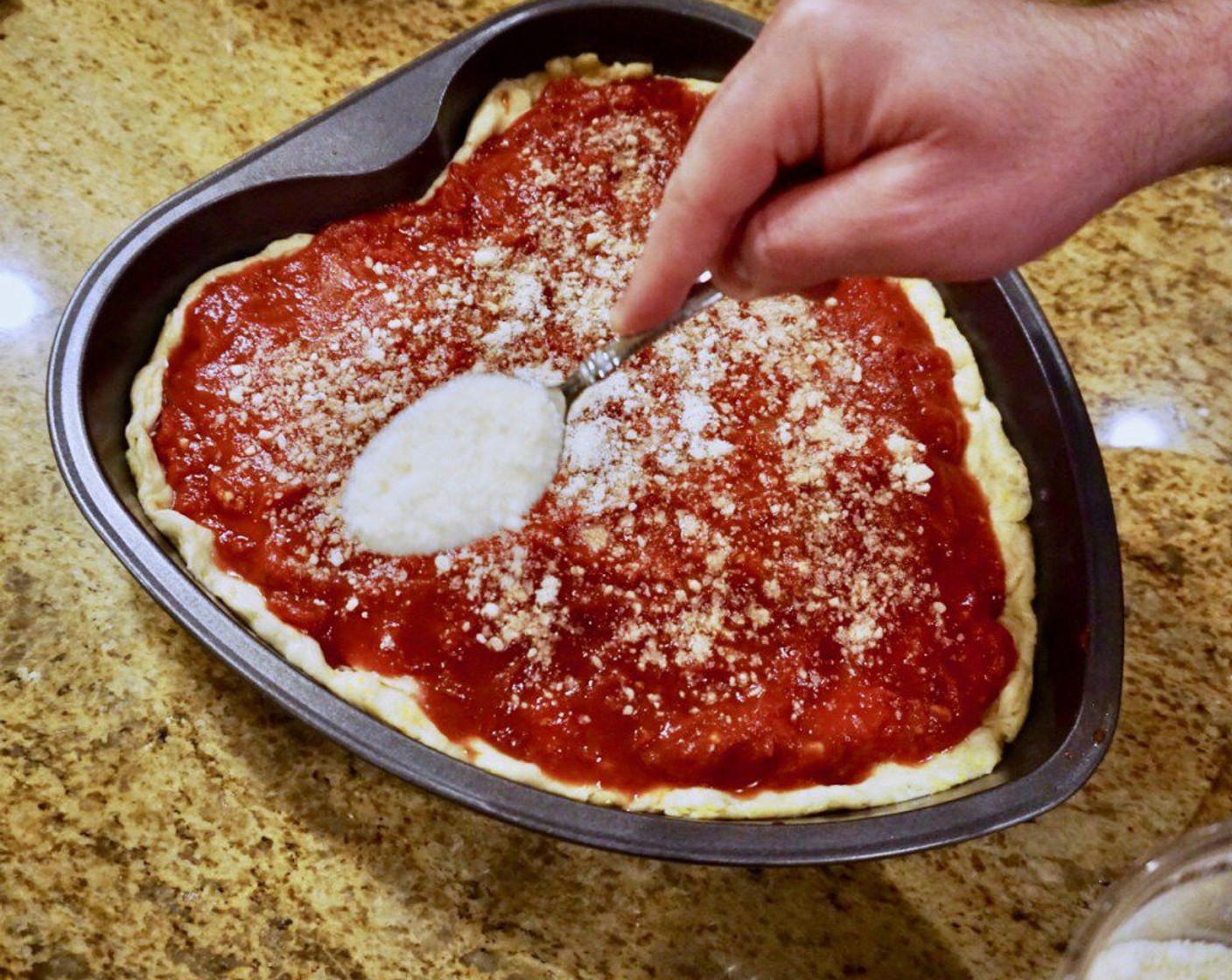 step 11 Top the dough with the sliced mozzerella, making sure you cut enough to cover the full surface of the dough. Pour your sauce over the cheese and use your hands or a spoon to spread it out evenly, coating the cheese. Top with Parmesan Cheese (1/4 cup) and McCormick® Garlic Powder (1 Tbsp).