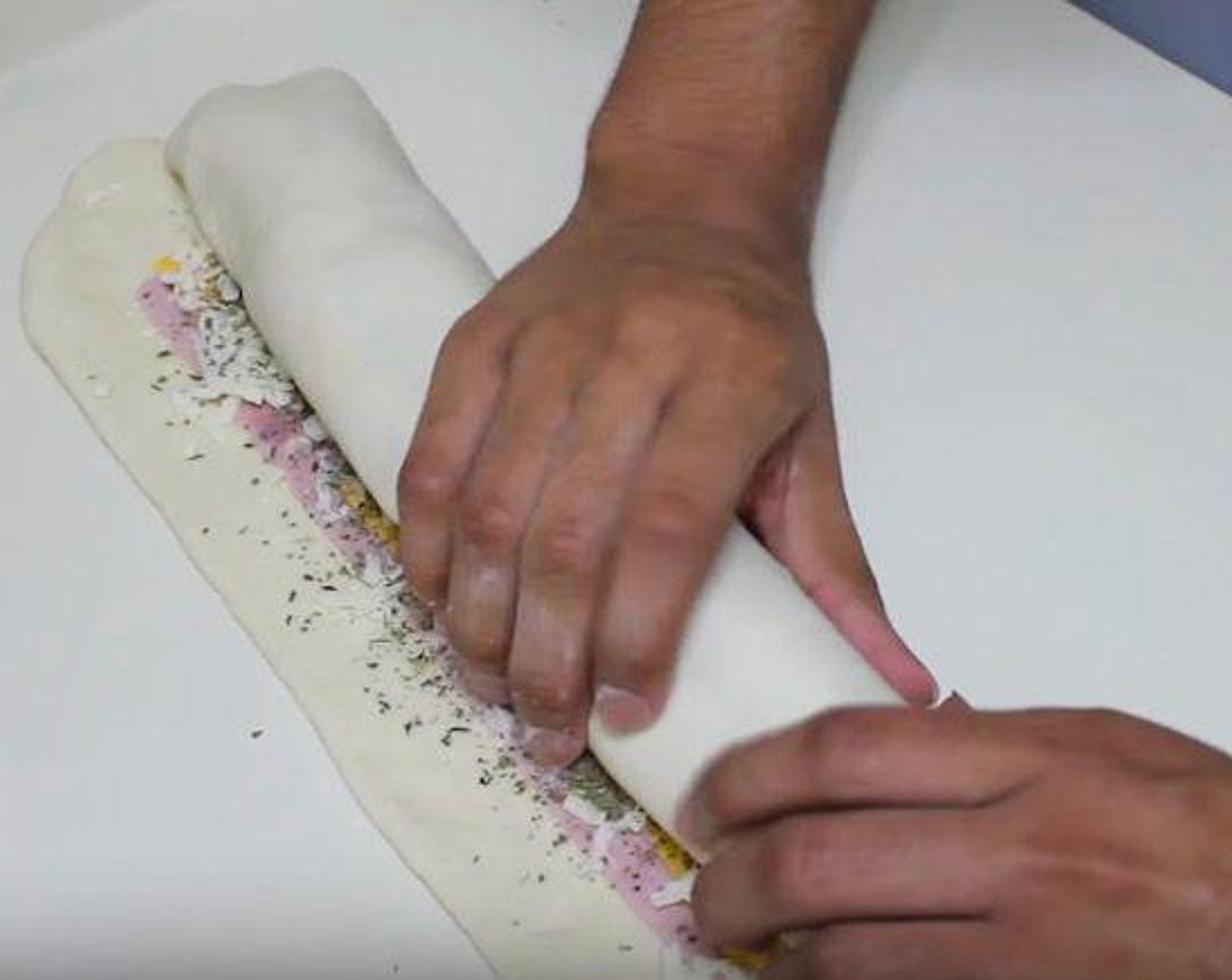 step 3 Roll the dough up as if you were making cinnamon rolls. Pinch the ends and bottom to seal. Transfer the roll to a baking sheet.