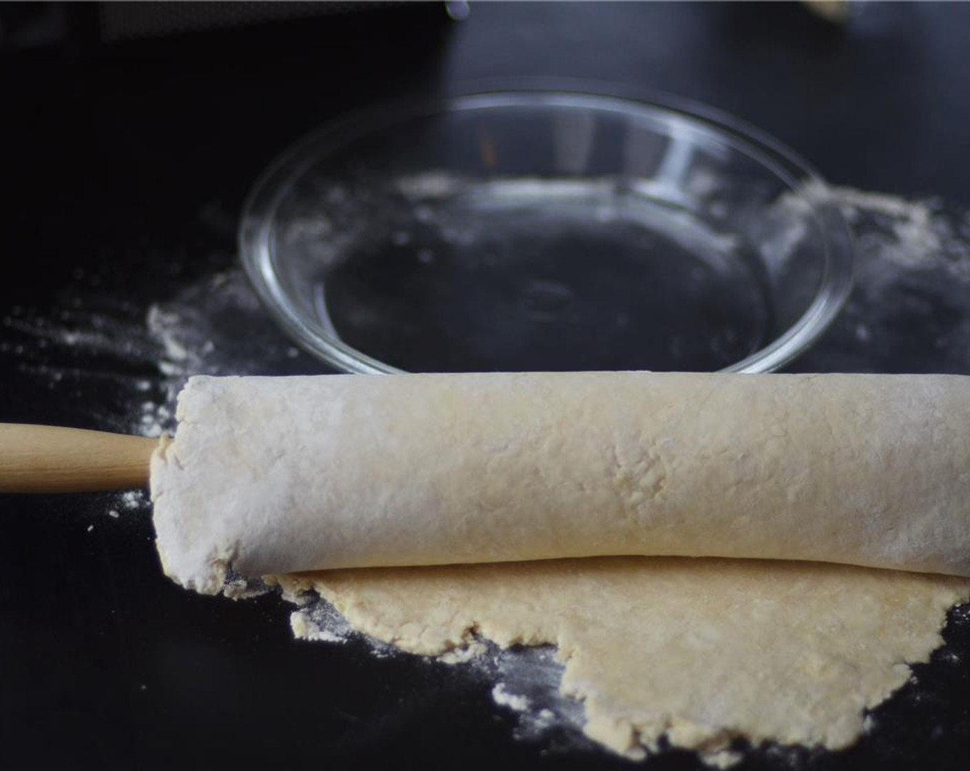 step 7 After one hour, remove dough from fridge and on a lightly floured surface roll dough out into a 12 inch wide circle. Transfer pie dough to a 9 inch pie dish and without stretching dough, tuck the pie dough into the dish.