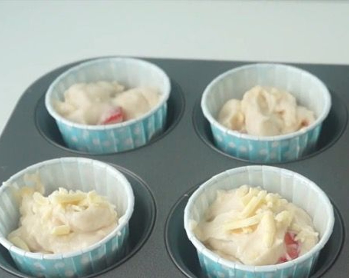 step 6 Scoop a ladle of the muffin base into each of the muffin cups. Using an ice cream scooper will make it easier to get even portions, and creates less mess!