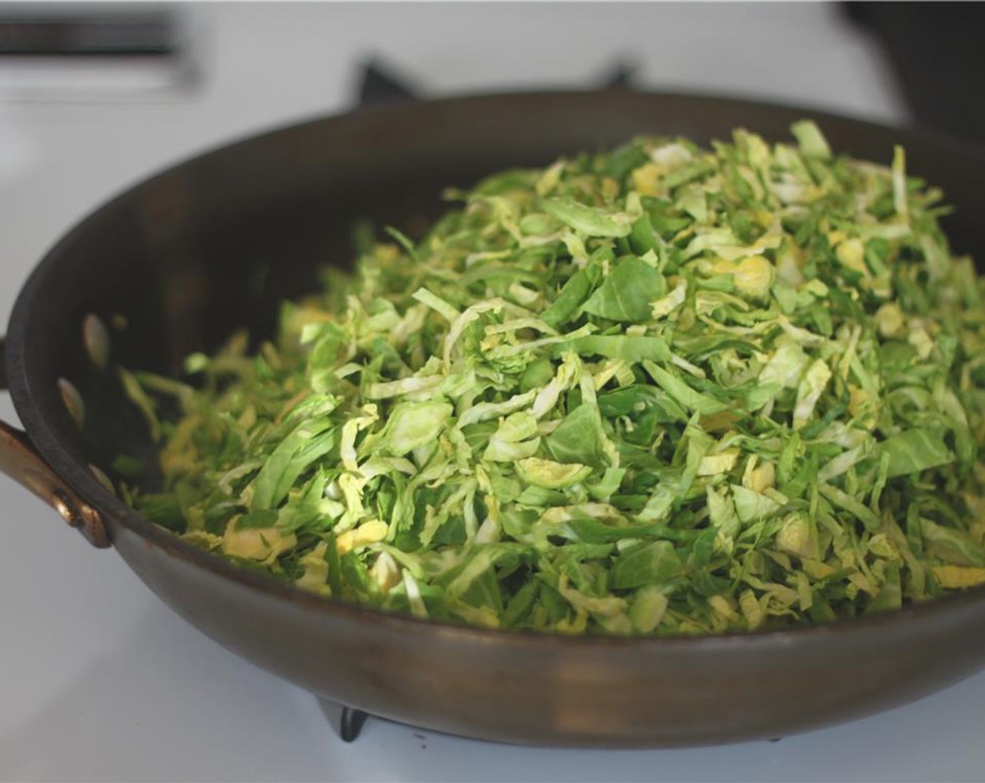 step 3 Over low heat, warm up a little olive oil in a large pan.  Add the shredded brussels sprouts and continuously stir over low heat until warmed through.  This will brighten and the color and the flavor.