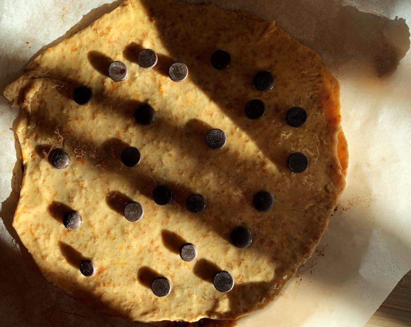 step 7 Roll the second piece, place it on top of the first one then brush it with melted coconut oil and cover it with some Dark Chocolate Chips (1/3 cup).