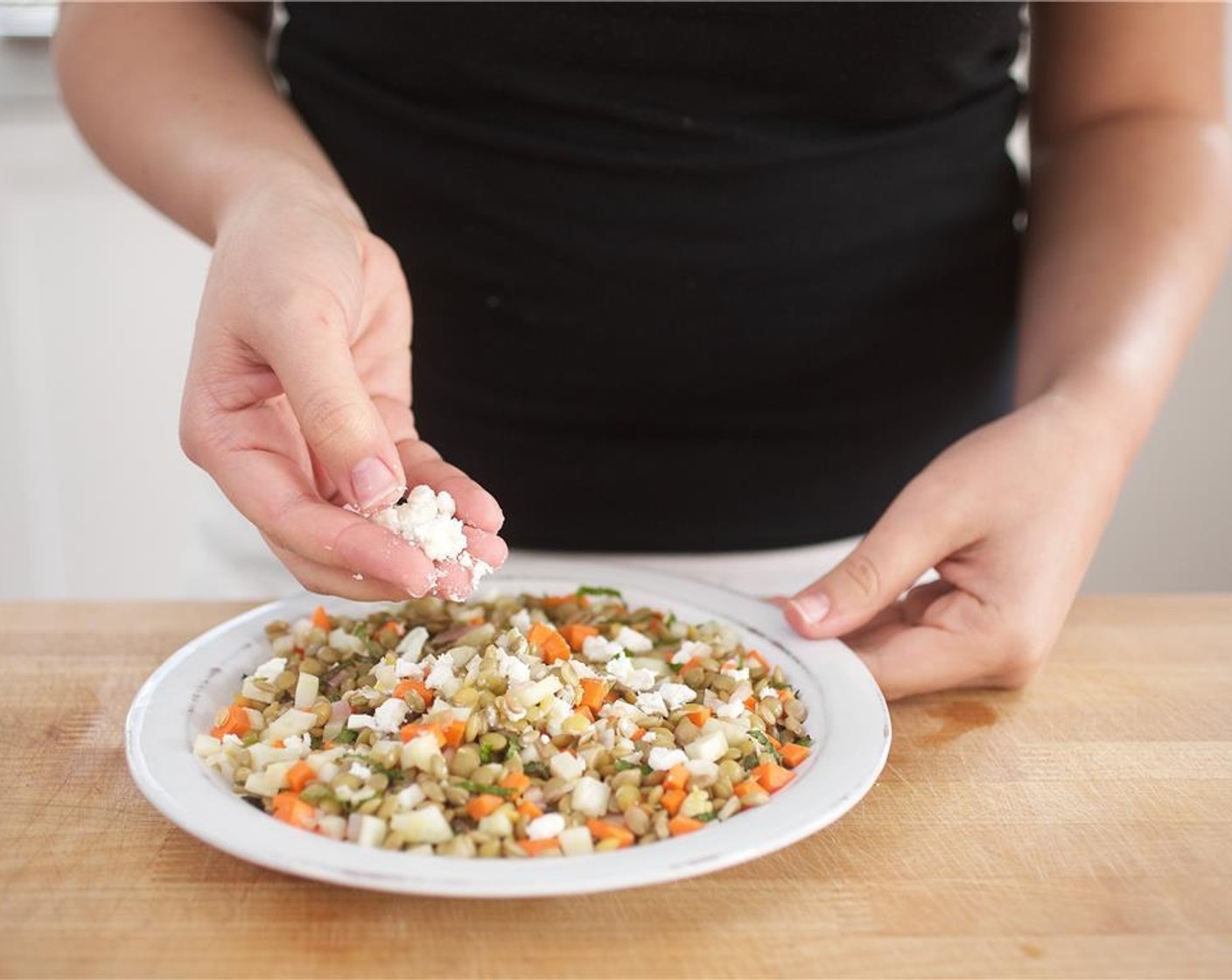 step 9 Divide the lentil salad between two plates. Crumble remaining Goat Cheese (2 Tbsp) over the salad.