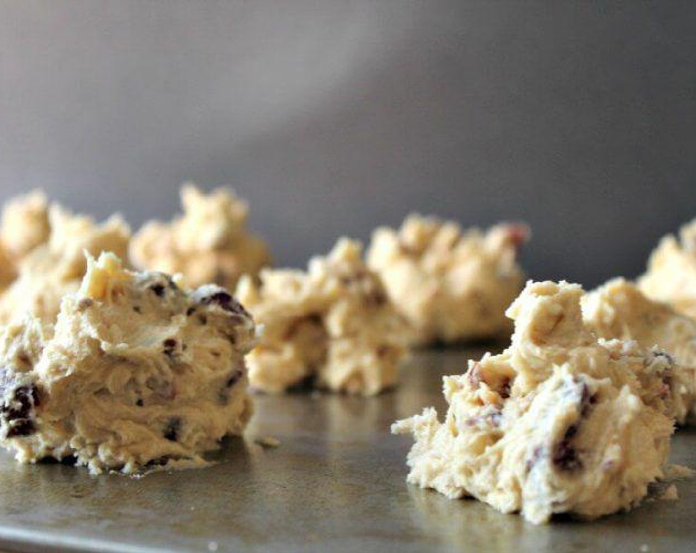 step 6 Line a baking sheet with parchment paper. In heaping tablespoon size balls, place cookie dough 2 inches apart on the baking sheet. Cook for around 12 minutes, checking a little earlier in case your oven runs hot.