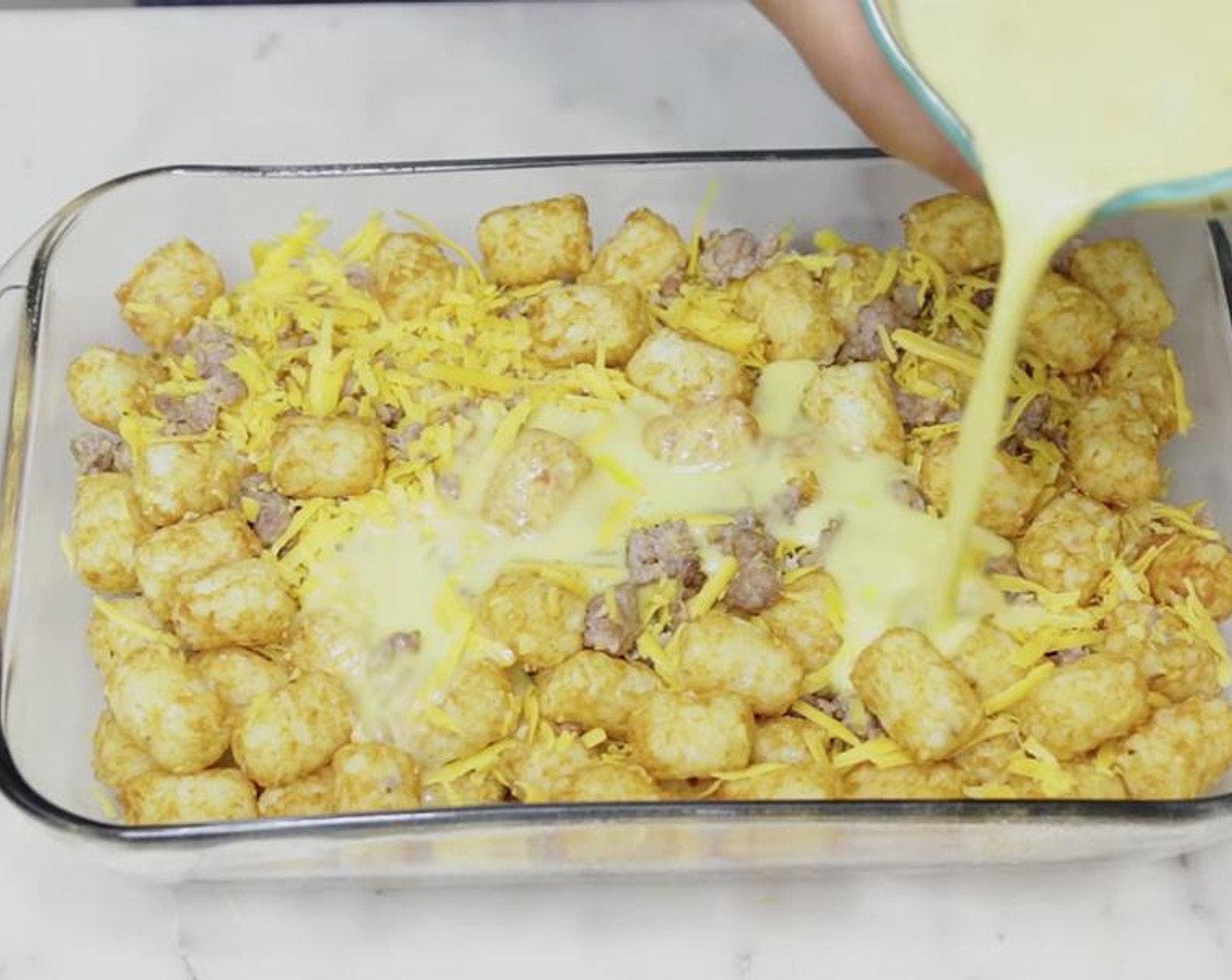 step 4 In a large bowl, toss together Frozen Tater Tots (9 cups), sausage and Cheddar Cheese (2 cups). Pour into baking dish. Pour the egg mixture all over. Sprinkle more cheese if you wish.