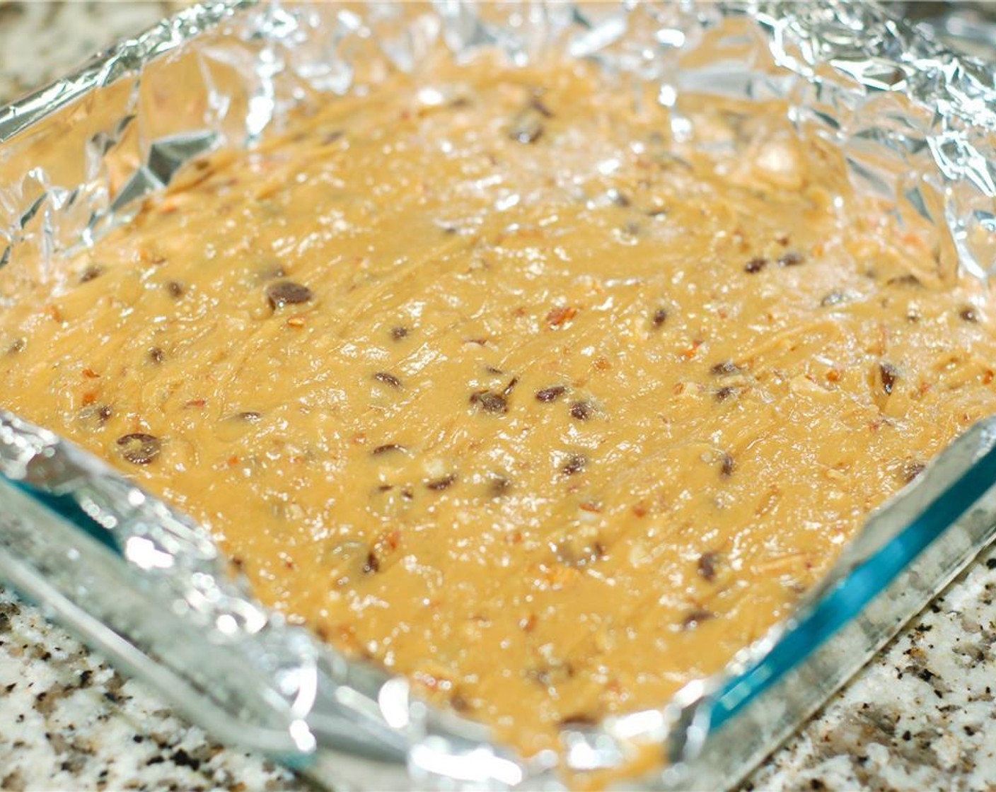 step 8 Spoon the batter into the lined baking dish. Bake for 25 to 26 minutes or until a toothpick inserted in the center comes out almost clean.