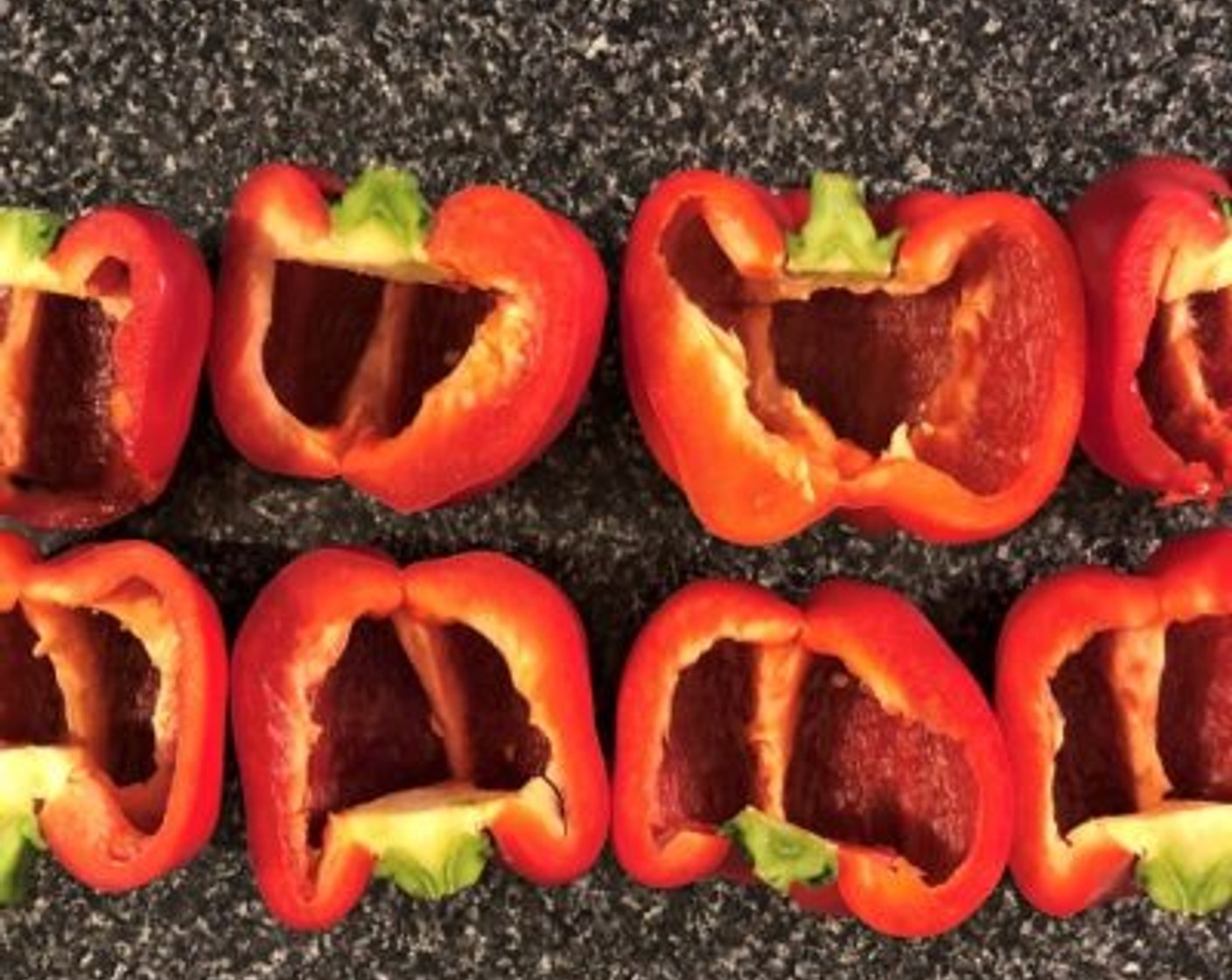 step 2 Slice the Red Bell Peppers (4) in half top to bottom. Remove the seeds and membrane carefully using a paring knife. Place the hollowed peppers on the tray.