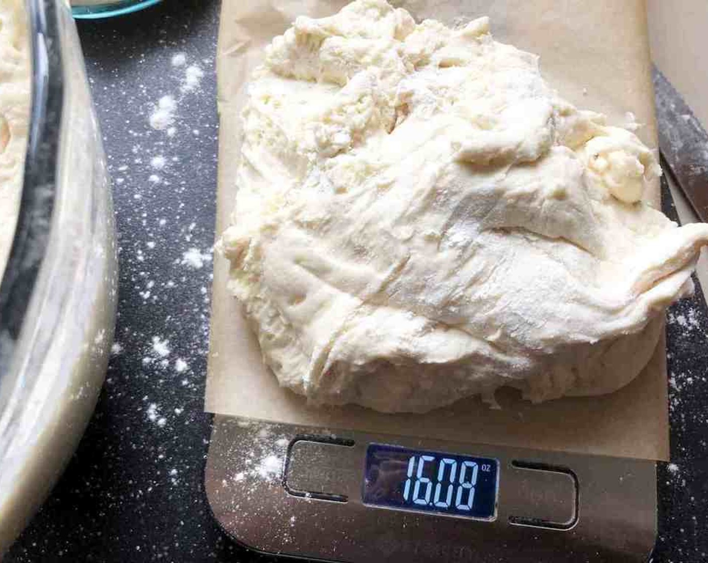 step 7 Grab that refrigerated container of prepared dough and sprinkle the surface of the dough with flour. Pull up and cut off a piece of dough weighing about 16 oz.