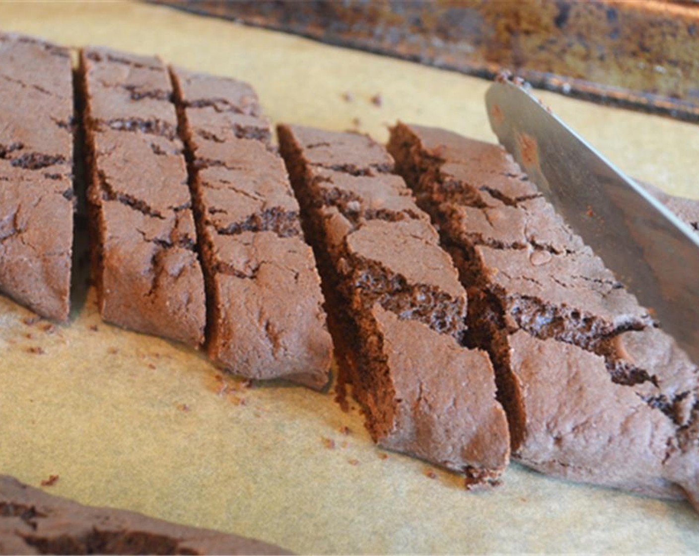 step 10 Let the biscotti logs cool on the pan for about 5 minutes, or until just cool enough to touch (if you wait any longer, the biscotti will be difficult to cut); then, using a sharp knife, slice the logs on the diagonal into 3/4-inch slices (I do this right on the baking sheet).