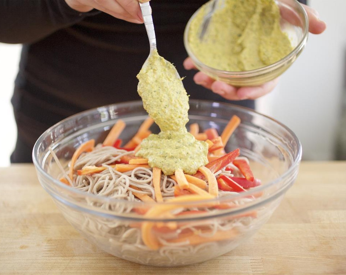 step 12 Transfer to large bowl with pepper and carrots. Toss noodles with Olive Oil (1 Tbsp). Add Asian pesto and toss until the all ingredients are well coated.