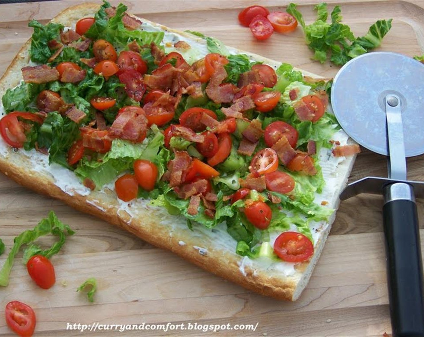 step 5 Allow naan to cool, then apply cream cheese and layer with the Romaine Lettuce (1 bunch), Grape Tomatoes (2 cups), Salt (to taste), Ground Black Pepper (to taste), and bacon bits. Serve immediately.