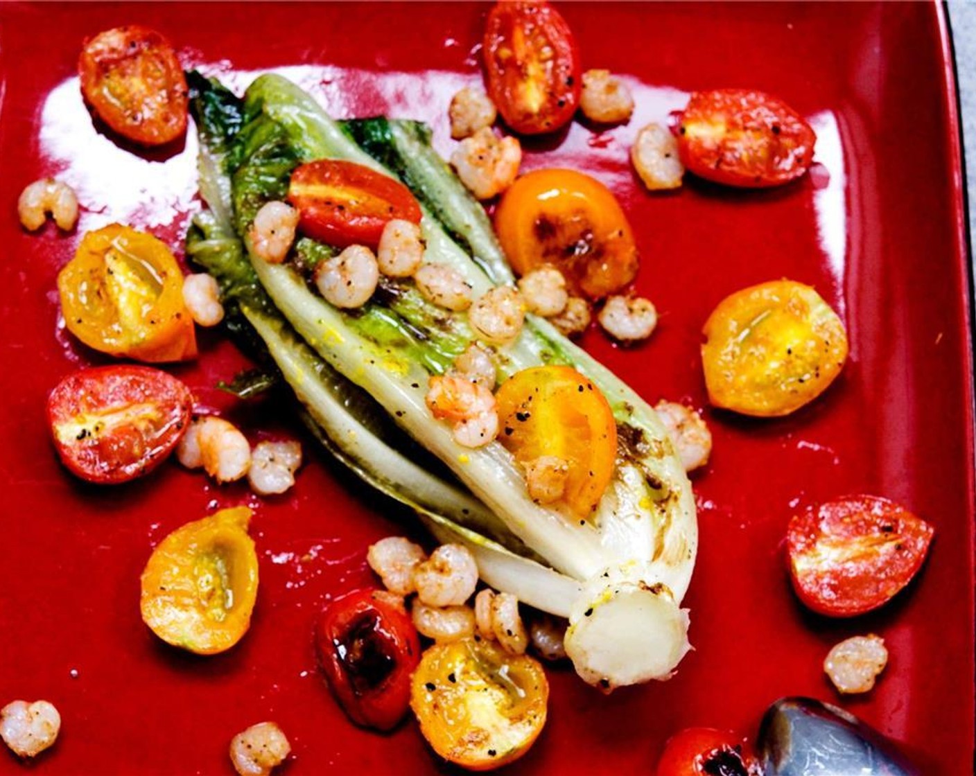 step 12 Place the grilled romaine hearts on a plate. Cover with shrimp and tomatoes.