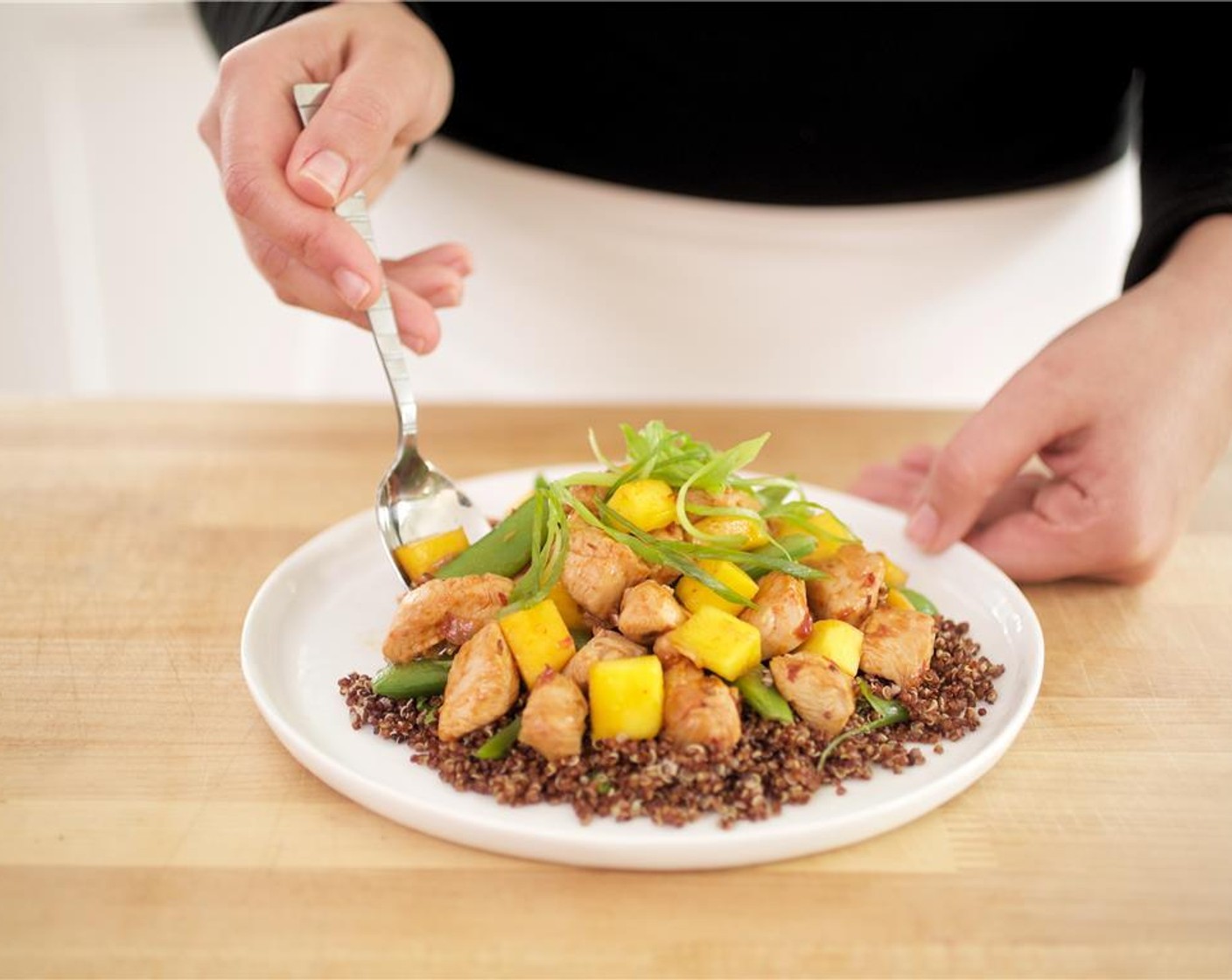 step 13 In the center of two plates, plate quinoa and place chicken stir-fry over the top. Garnish with remaining green onions.