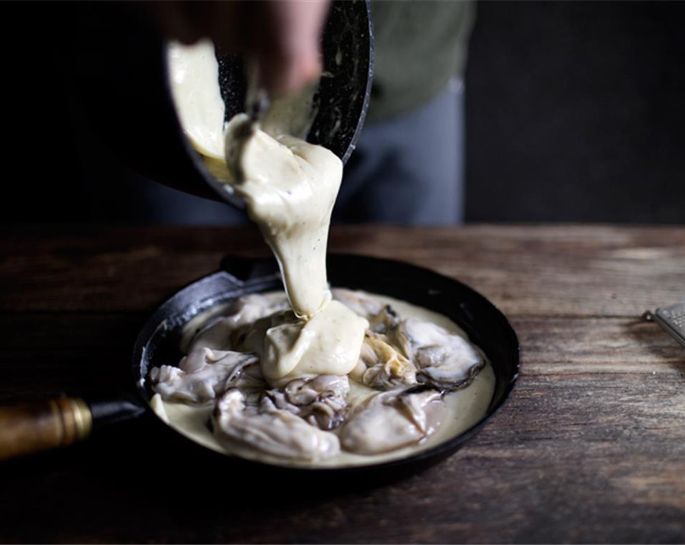 step 5 Preheat the top broiler on high. In a shallow oven-proof skillet, spread half of the cheese sauce on the bottom, then arrange the oysters evenly and cover with the rest of the cheese sauce.