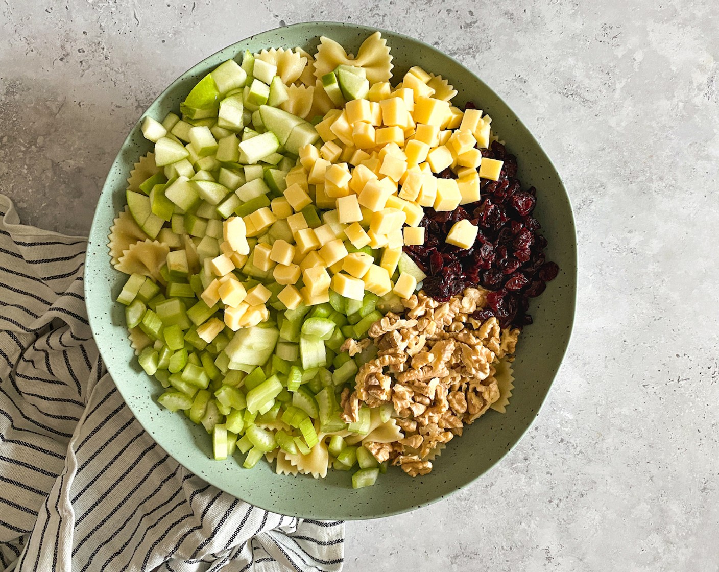 step 6 Once pasta is cooled completely, in a large bowl, add the pasta, apple, celery, Dried Cranberries (1 cup), and cheese.