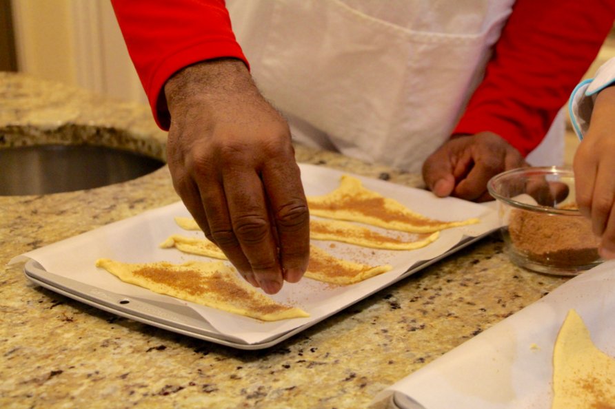 Step 6 of Apple Pie Bites Recipe: Sprinkle sugar mixture evenly among triangles then place an apple slice at the wide end of the triangle.