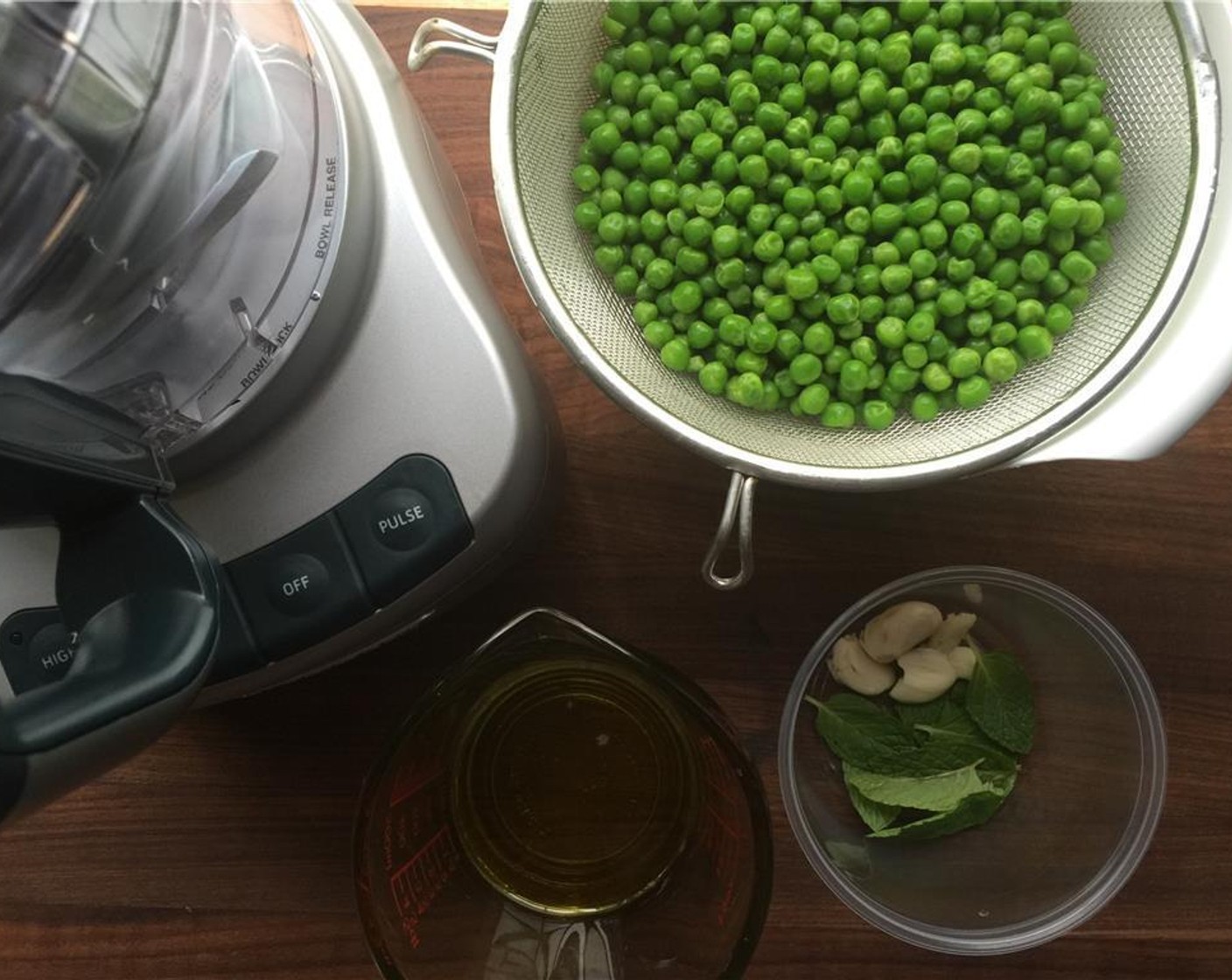 step 1 Place Frozen Green Peas (4 cups), Fresh Mint Leaves (10), Garlic (2 cloves), Salt (1/2 tsp), Ground Black Pepper (1/8 tsp), and Extra-Virgin Olive Oil (1/3 cup) in a food processor.