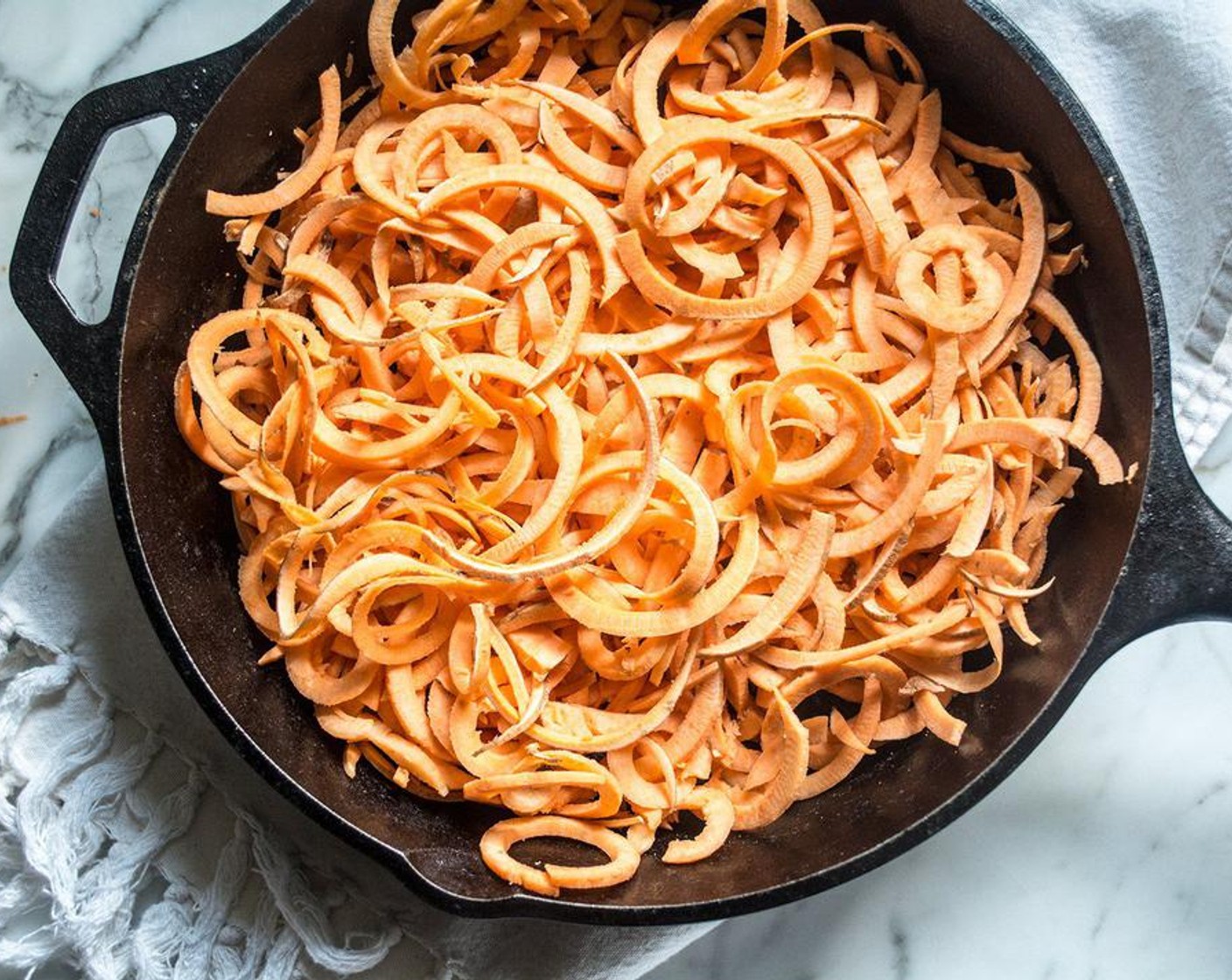 step 2 Spiralize Sweet Potatoes (4 cups), then layer in cast iron skillet or oven safe casserole dish.