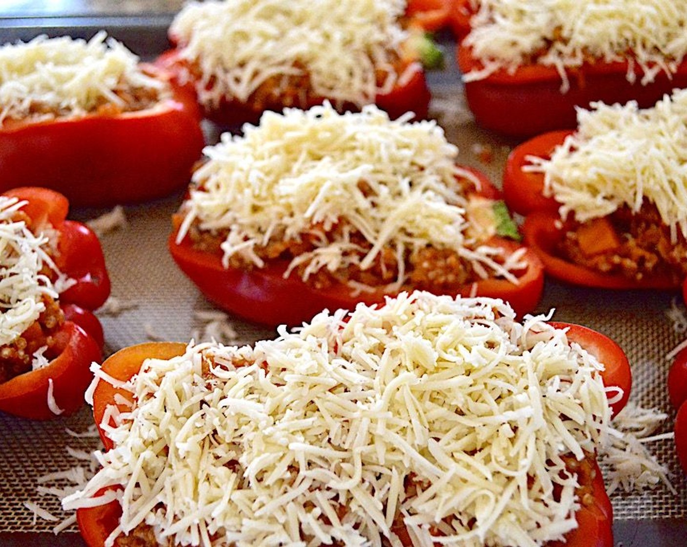 step 8 Lay out the Red Bell Peppers (4) halves on the tray, then stuff all of them to the brim with filling, really packing it in tightly. Sprinkle the Smoked Gouda (1 1/2 cups) generously on top of each stuffed pepper, then bake them for 10 minutes to make the cheese bubbly.