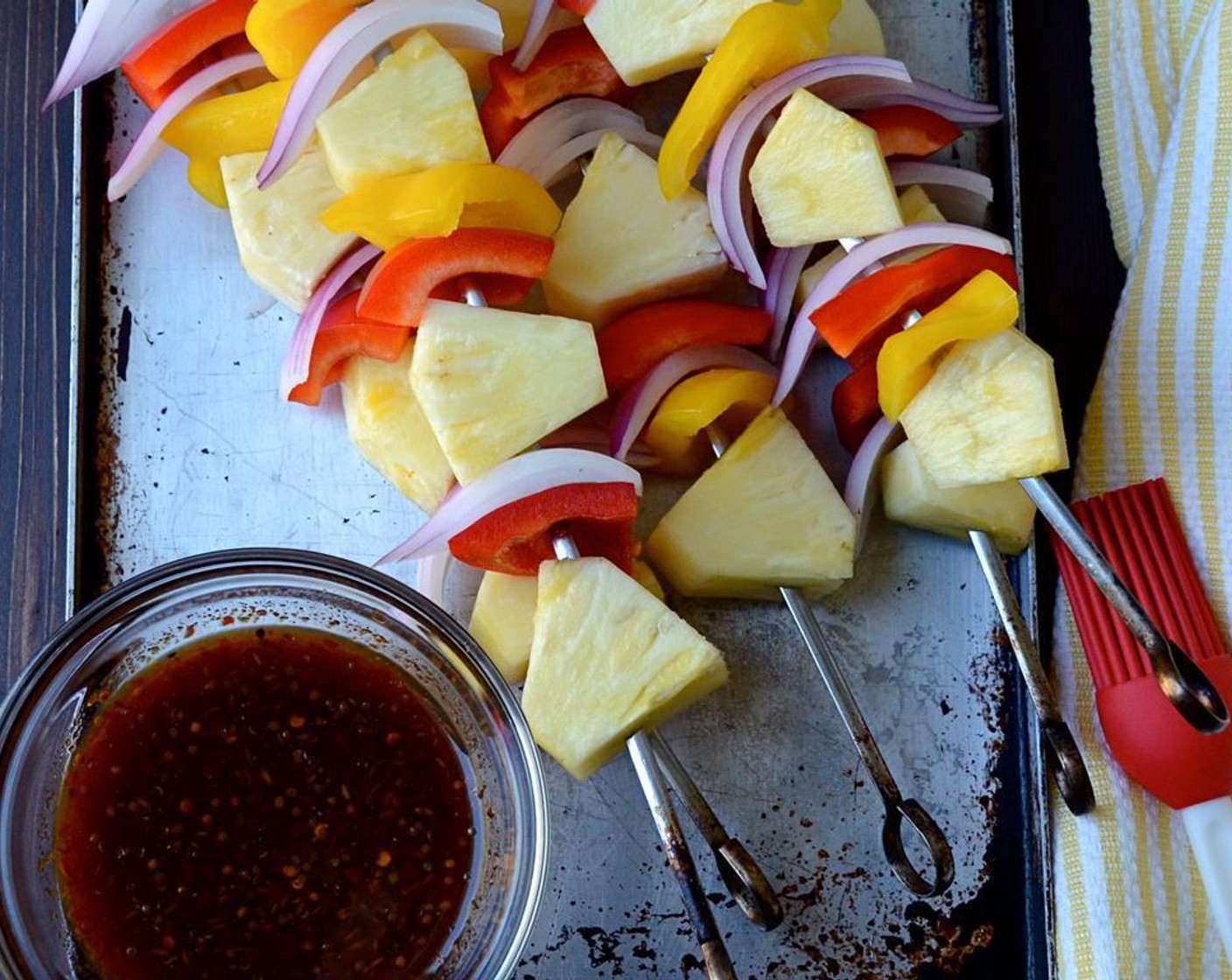 step 5 Meanwhile, alternate threading the Fresh Pineapple Chunks (2 cups), Red Bell Pepper (1), Yellow Bell Pepper (1), and Red Onion (1/2) onto metal or pre-soaked wooden skewers.