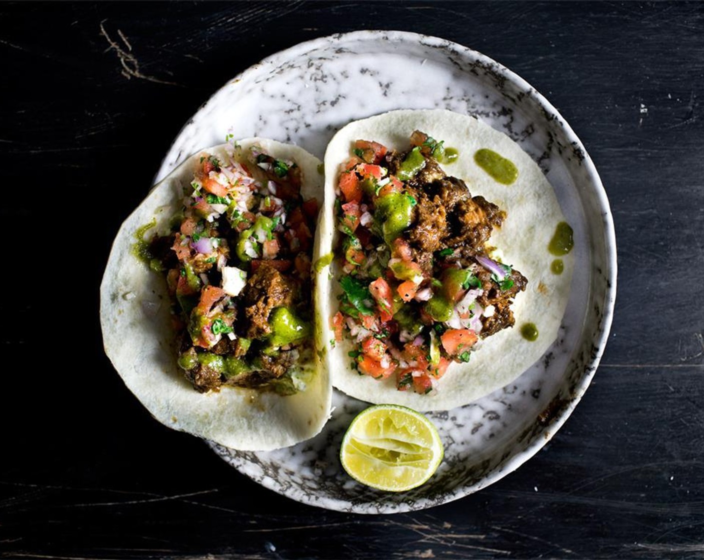 step 12 Re-toast or steam the Small Flour Tortillas (12) until warm. Smear a generous amount of avocado cream on the bottom, then top with jerked sriracha roast pork and tomato toppings. Serve with lots of kiwi salsa verde and fresh lime.