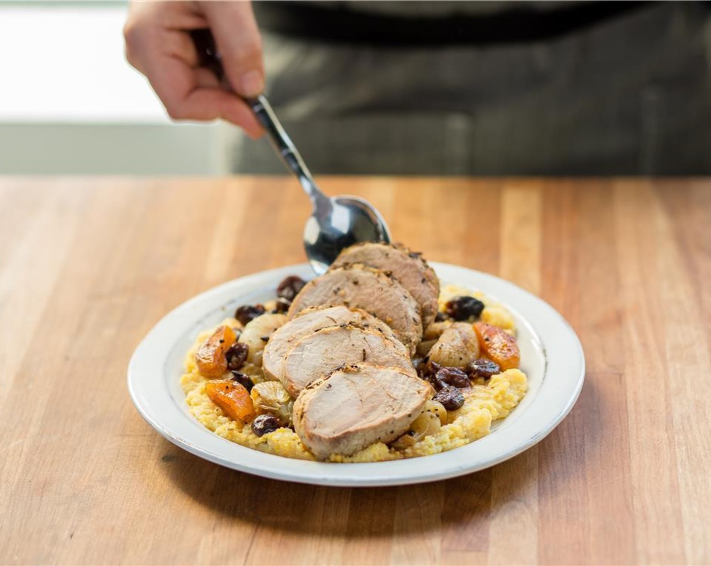 step 9 In the center of two plates, place the polenta and evenly distribute the pork tenderloin. Drizzle with the remaining sauce from the saute pan.