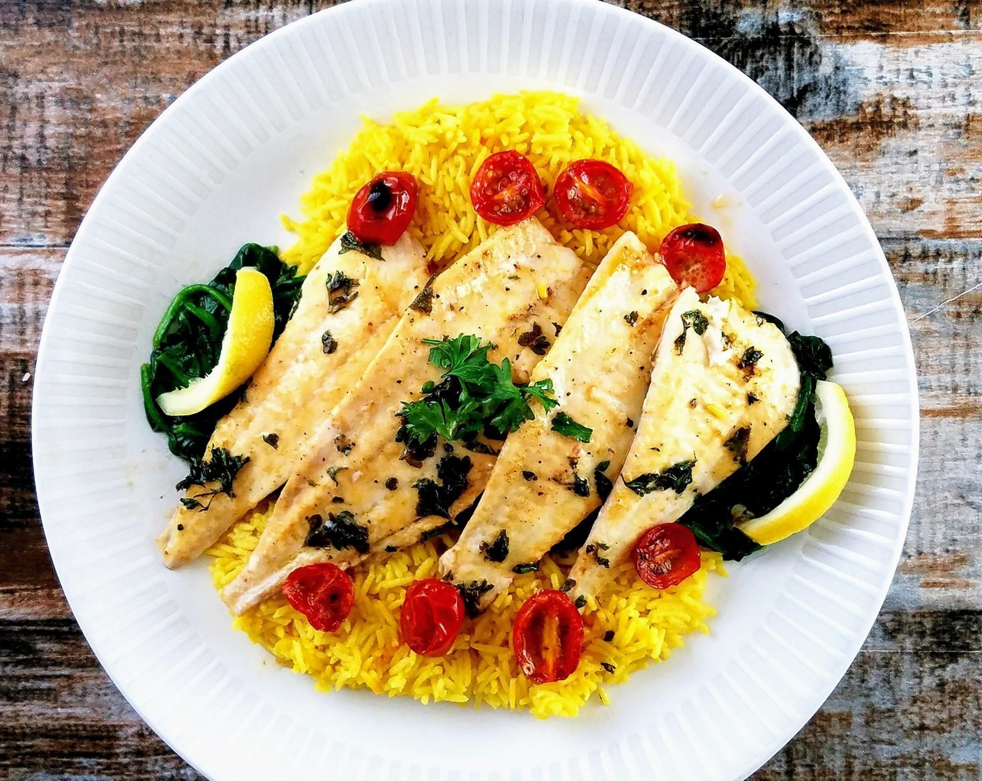 step 4 Remove the fish from the oven and plate with the tomatoes. Spoon any sauce over the fish, squeeze fresh lemon juice on top. Garnish with extra parsley if desired.