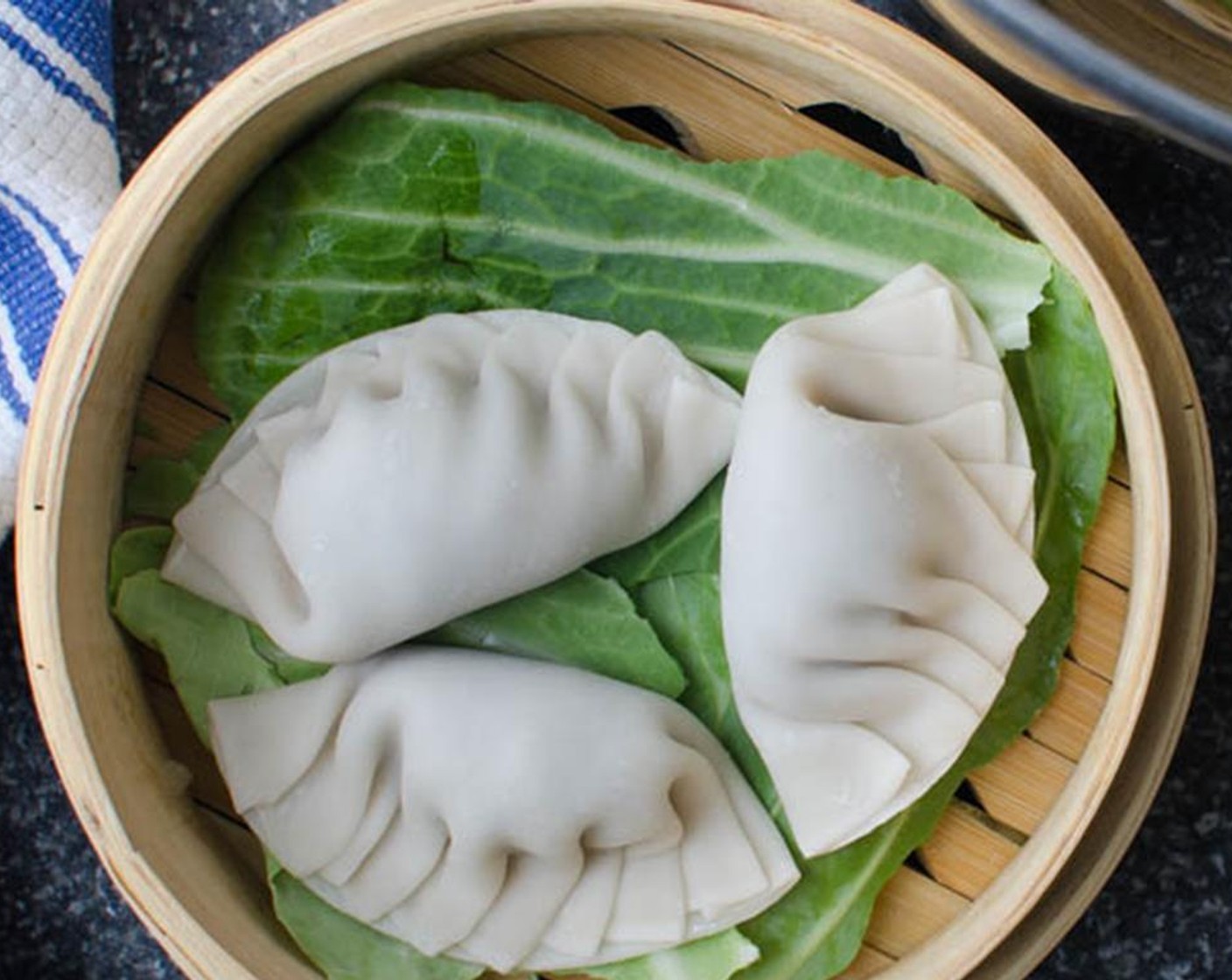 step 7 Add 1-inch of water to a large pot and bring to a boil. Arrange a few cabbage leaves on the bamboo steamer or the steaming basket.