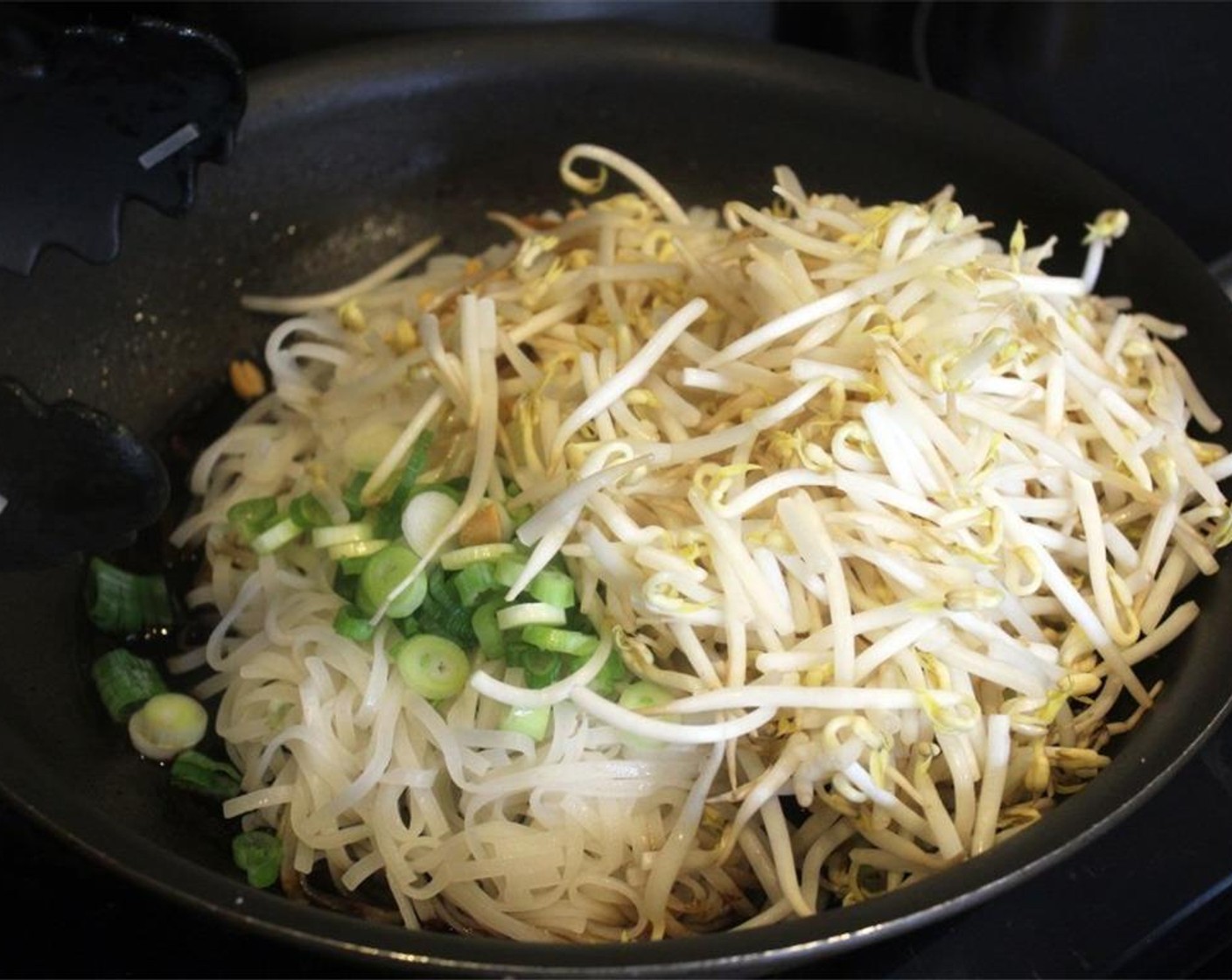 step 11 To the pan with the cooled beef sauce, add the rice noodles, scallion, Bean Sprouts (2 cups) and half of the peanuts.