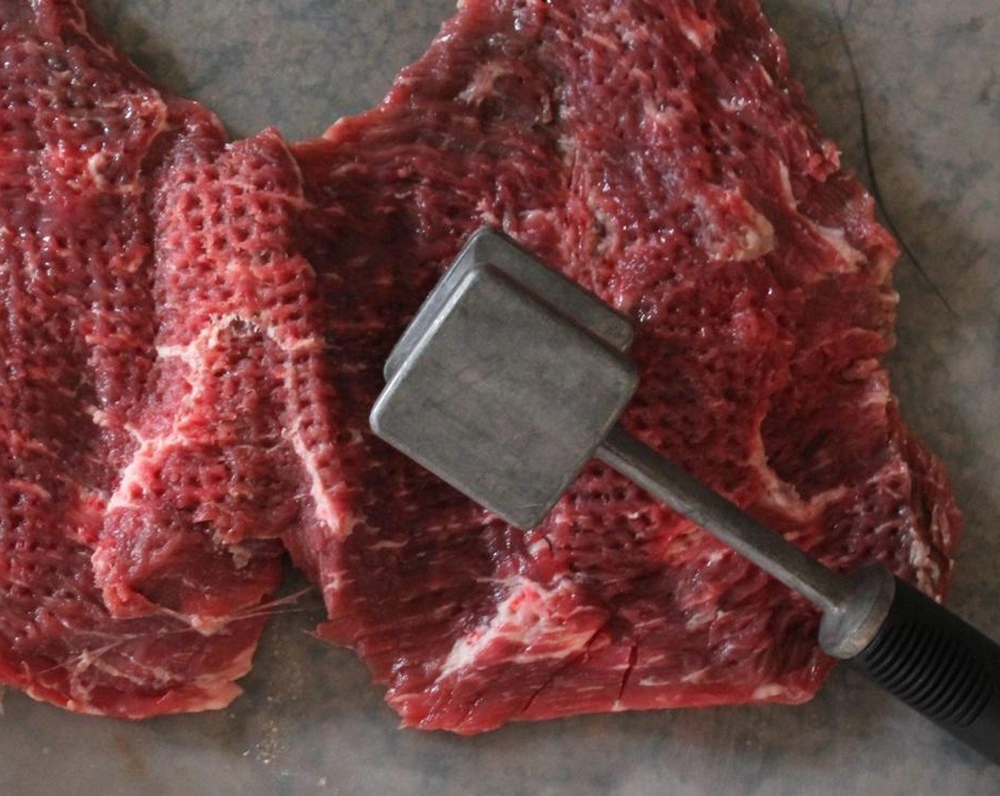 step 2 Lay your Flank Steak (2 lb) on a cutting board and pound steak. Season with Kosher Salt (to taste) and Freshly Ground Black Pepper (to taste) on both sides.