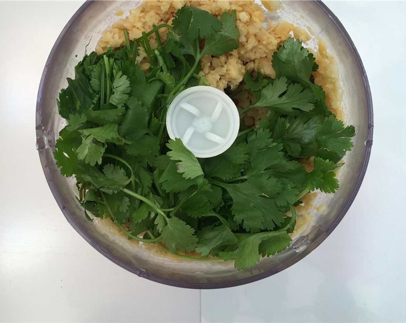 step 4 Pulse the chickpeas for 2 minutes. Scrape down the sides and pulse again. Then add Fresh Cilantro (1 handful), juice from Lemon (1) and half of the Sesame Oil (1 Tbsp).