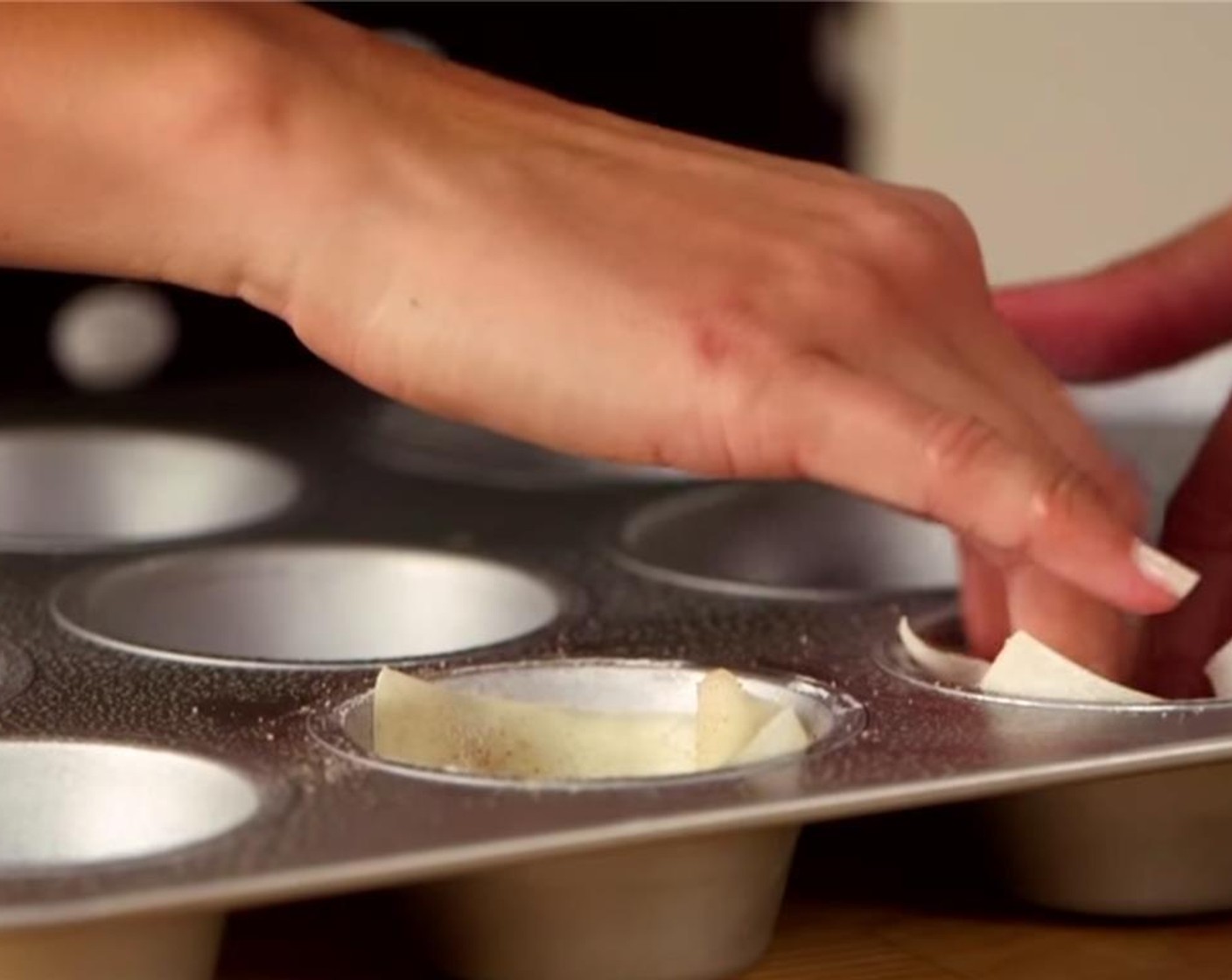 step 2 Spray a muffin tin with cooking spray and place Wonton Wrappers (12) inside.