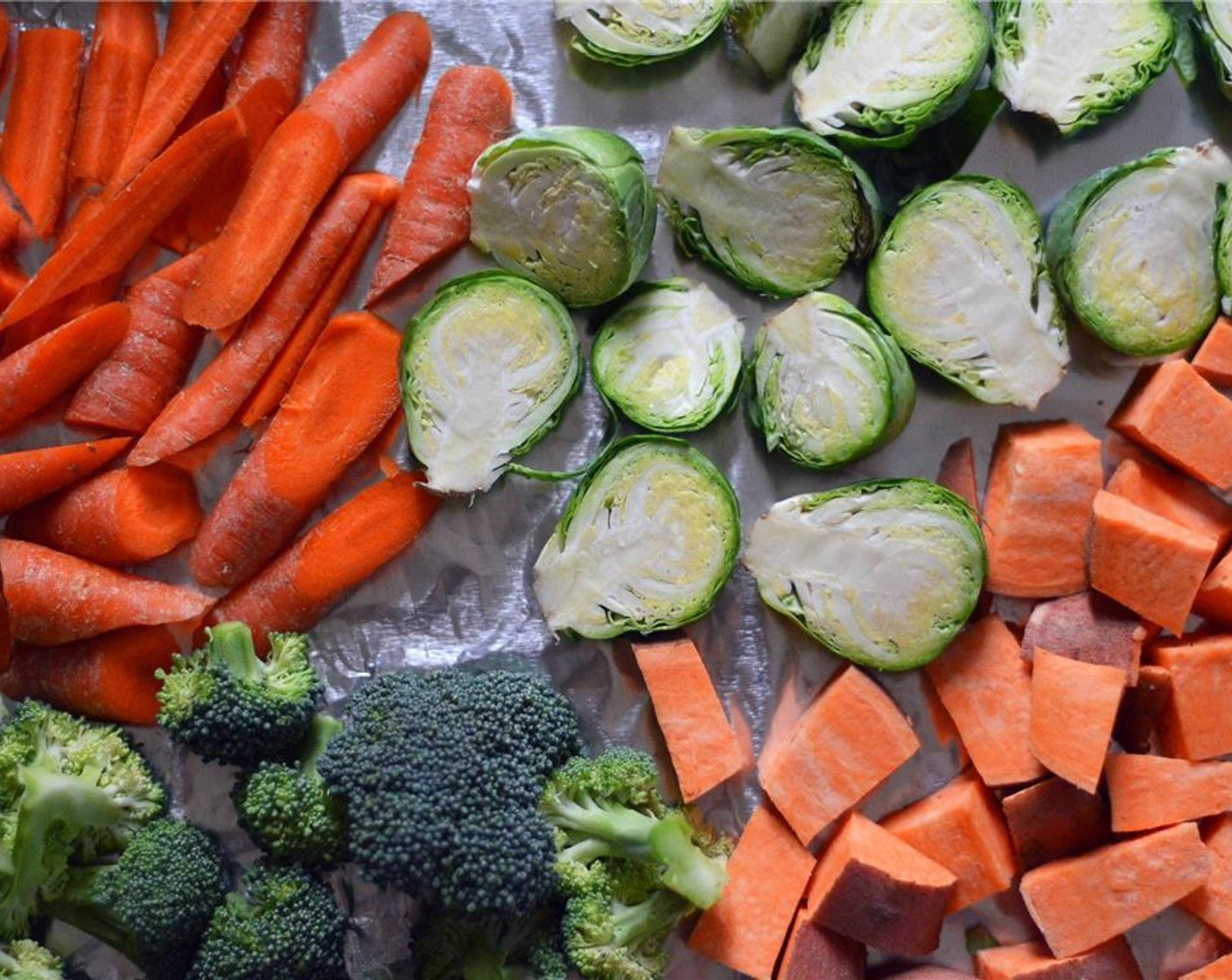 step 4 Line a large baking sheet with tinfoil and lay the chopped sweet potato, brussels sprouts, medium carrots, quartered yellow onion, and broccoli in a single layer on baking sheet. Drizzle with Olive Oil (2 Tbsp)