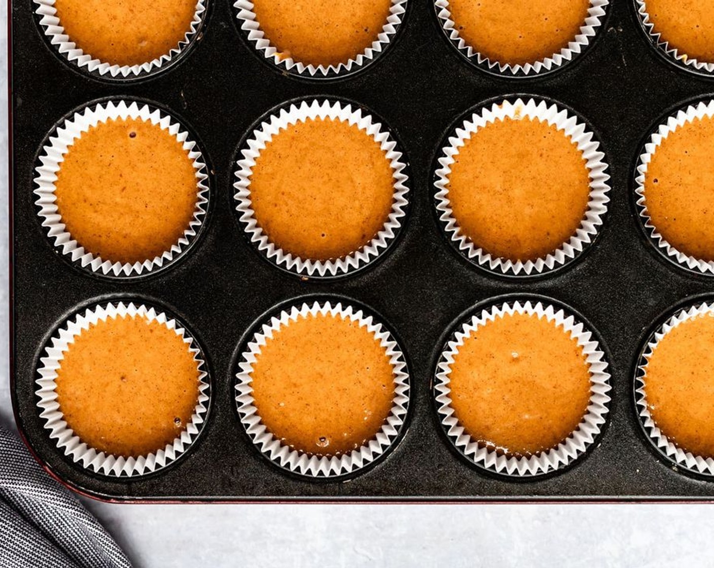 step 4 Spoon the batter evenly in all of the prepared muffin cups, filling each about 2/3 full (about 3 tablespoons of batter for each cupcake).