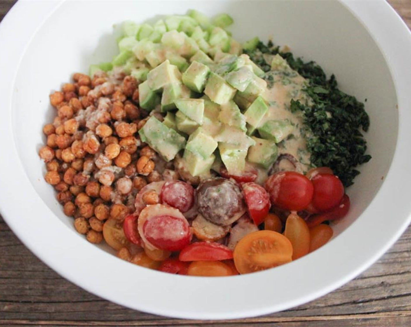 step 10 When the quinoa has cooled, add the Seedless Cucumber (1/2), Heirloom Cherry Tomato (1 cup), Fresh Spinach (2 cups), Avocado (1) and half of the cooked chickpeas to the bowl. Pour the dressing over everything.