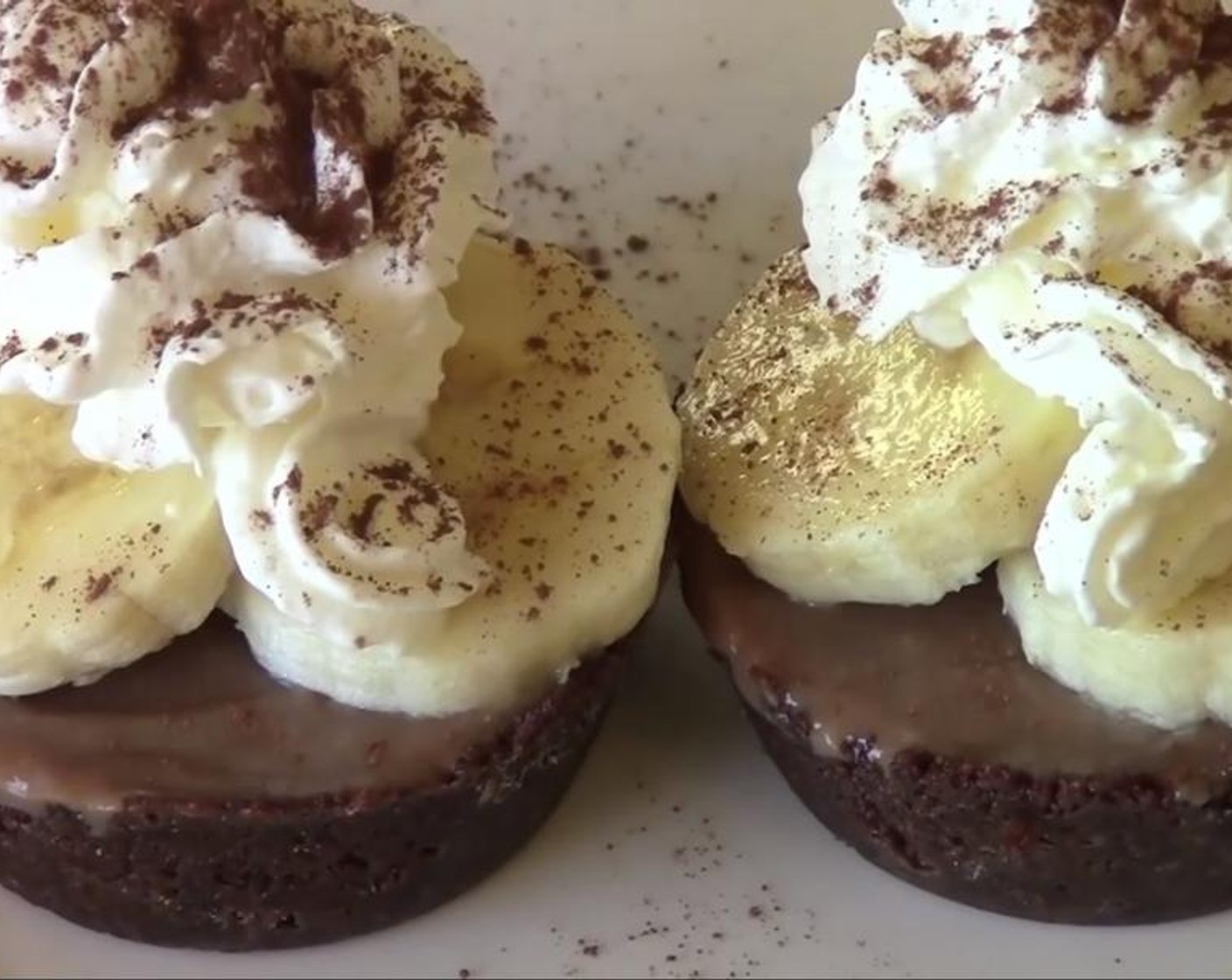 step 4 Take the pies out of the tray. Arrange slices of Bananas (2) on top of each pie. Top with Whipped Cream (to taste) and pour Unsweetened Cocoa Powder (1 tsp) over them. Serve!