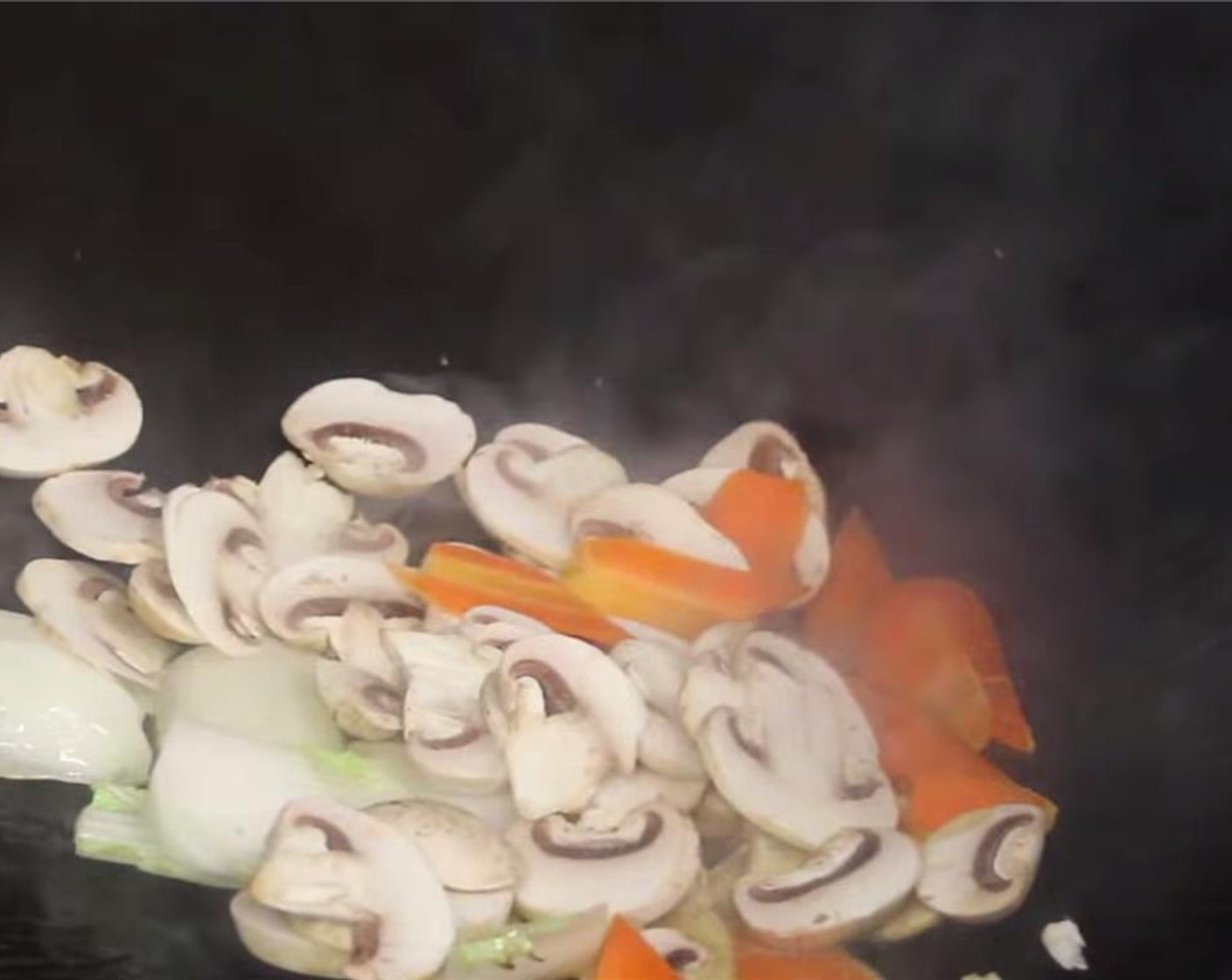 step 12 Add in the hard and thick vegetables into the wok first: napa cabbage stalk,  button mushrooms, carrots,  Bamboo Shoots (3 Tbsp), and Water Chestnuts (3 2/3 Tbsp). Stir fry for 10 seconds.