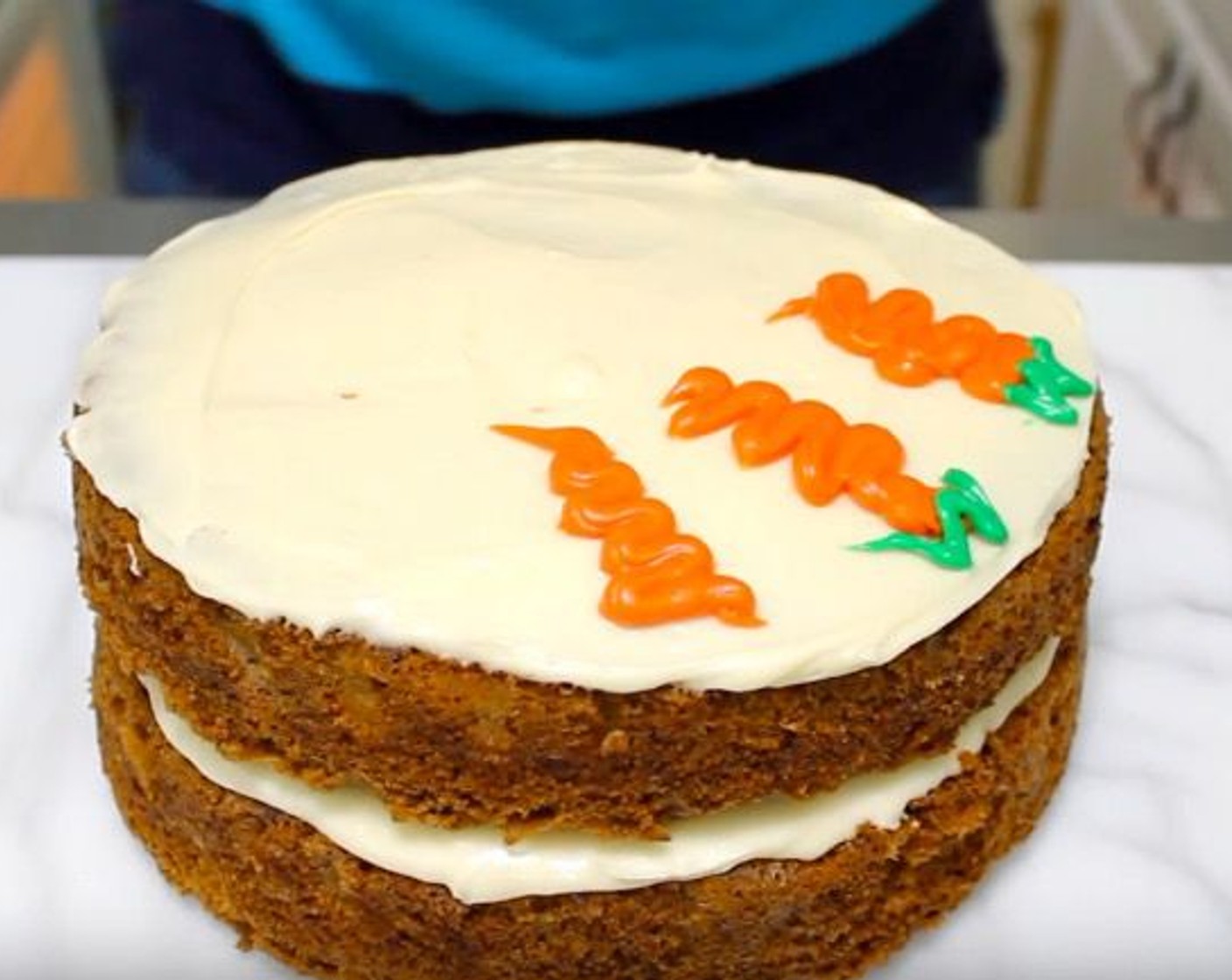 step 11 In two separate bowls, mix frosting with Orange Food Coloring Gel (to taste) and Green Food Coloring (to taste). Frost carrots onto the top of the cake for decoration.