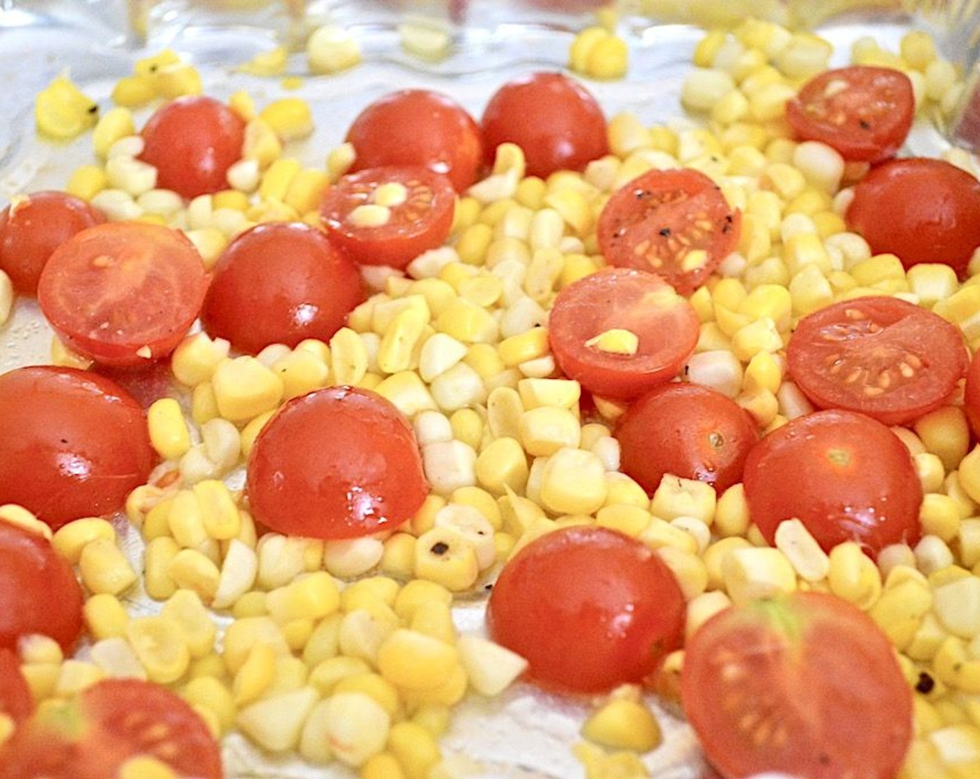 step 2 Get out a baking dish and combine the Corn (1 ear), Cherry Tomatoes (12), Salt (1 pinch), Ground Black Pepper (1 pinch), and Olive Oil (1 dash). Stir it all together thoroughly. Let them roast in the oven for 10 minutes.