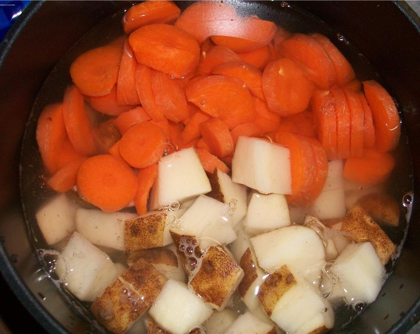 step 3 In a saucepan, boil chopped potato and chopped carrot.