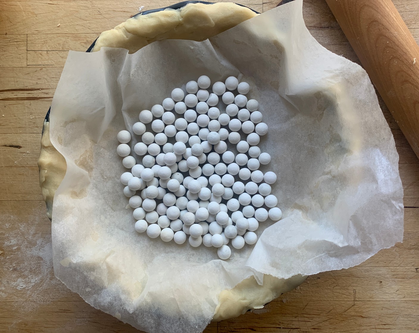 step 5 Remove the dough from the fridge and lightly prick the shell with a fork and line with foil or parchment and fill with pie weights or dried beans.