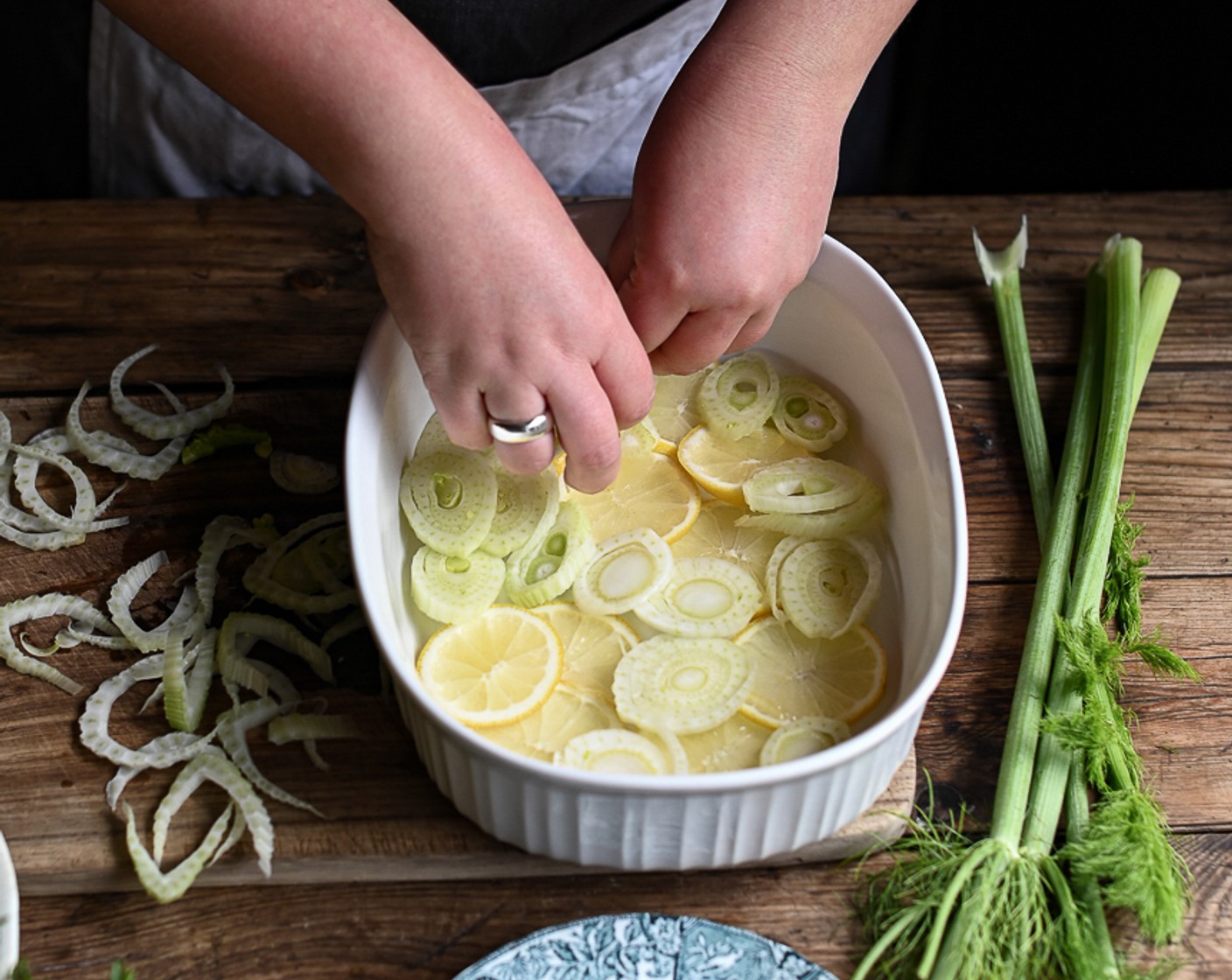 step 3 Drizzle a little Olive Oil (as needed) in the base of an ovenproof dish and layer over the fennel and lemon slices.